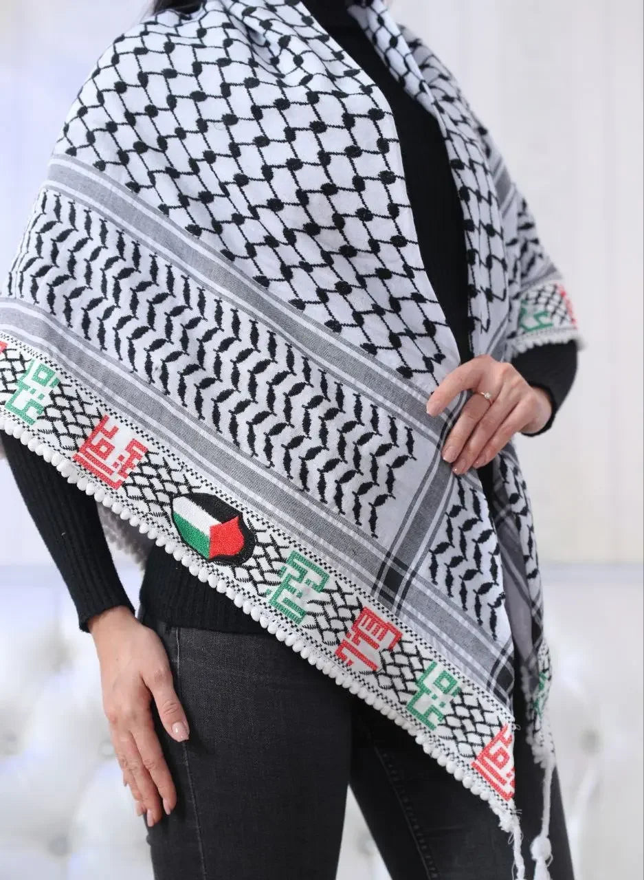 Embroidered Palestinian kuffiyeh shawl with traditional black and white pattern and colorful embroidery wrapped around a person