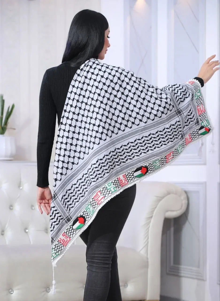 Woman wearing embroidered Palestinian kuffiyeh shawl with traditional black and white pattern and colorful border