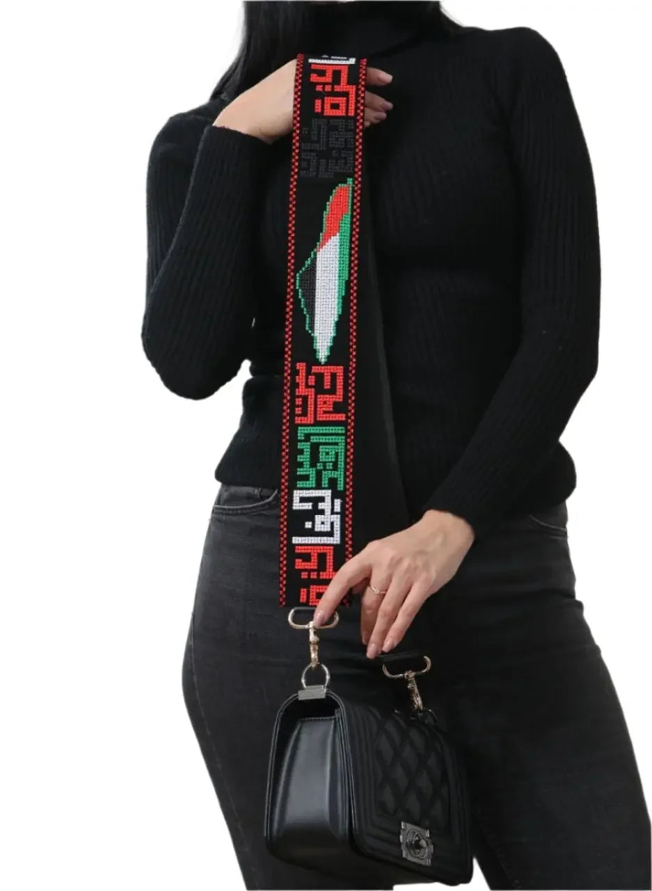 Palestinian embroidered purse strap with colorful traditional embroidery attached to a black quilted handbag