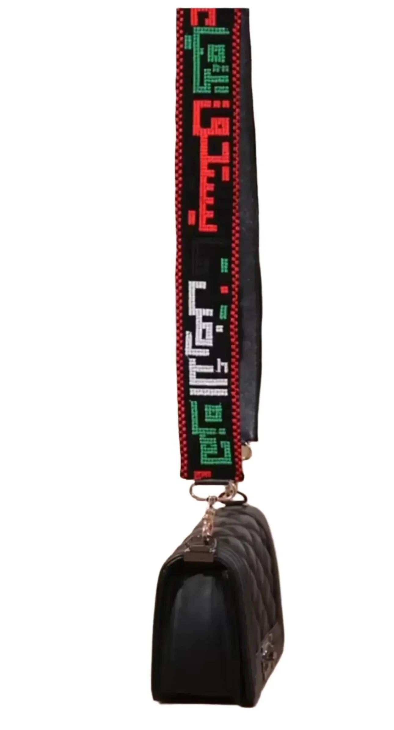 Palestinian embroidered purse strap with red, green, and white traditional patterns attached to black quilted purse