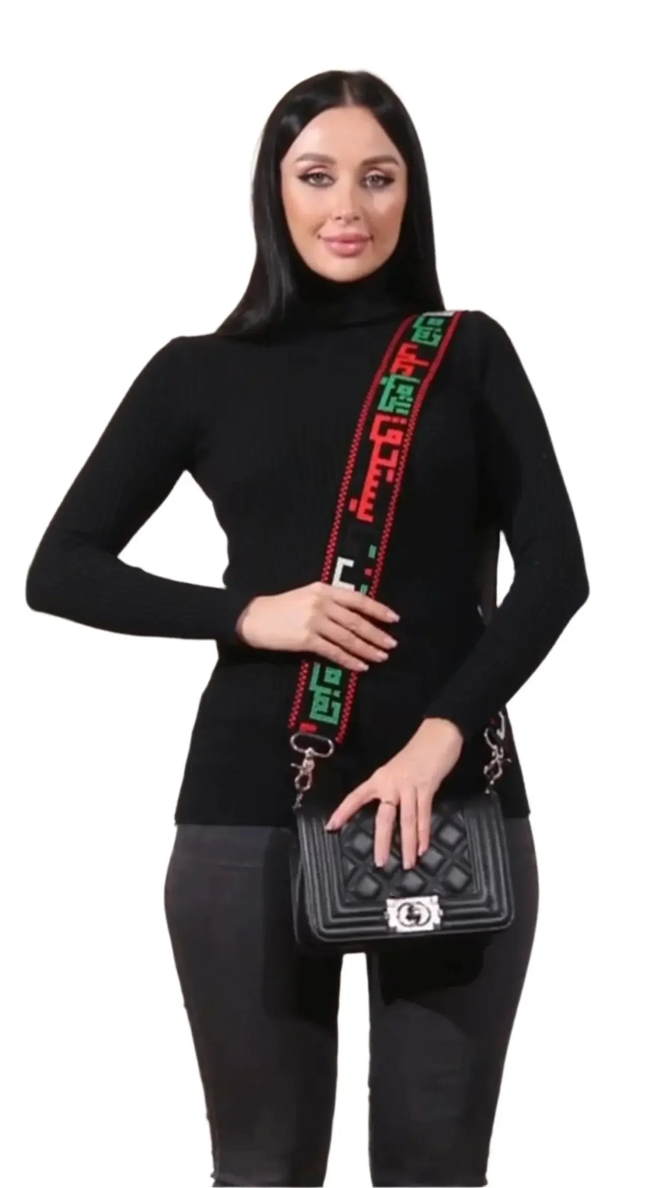 Woman wearing a black outfit with a Palestinian embroidered purse strap attached to a black quilted handbag