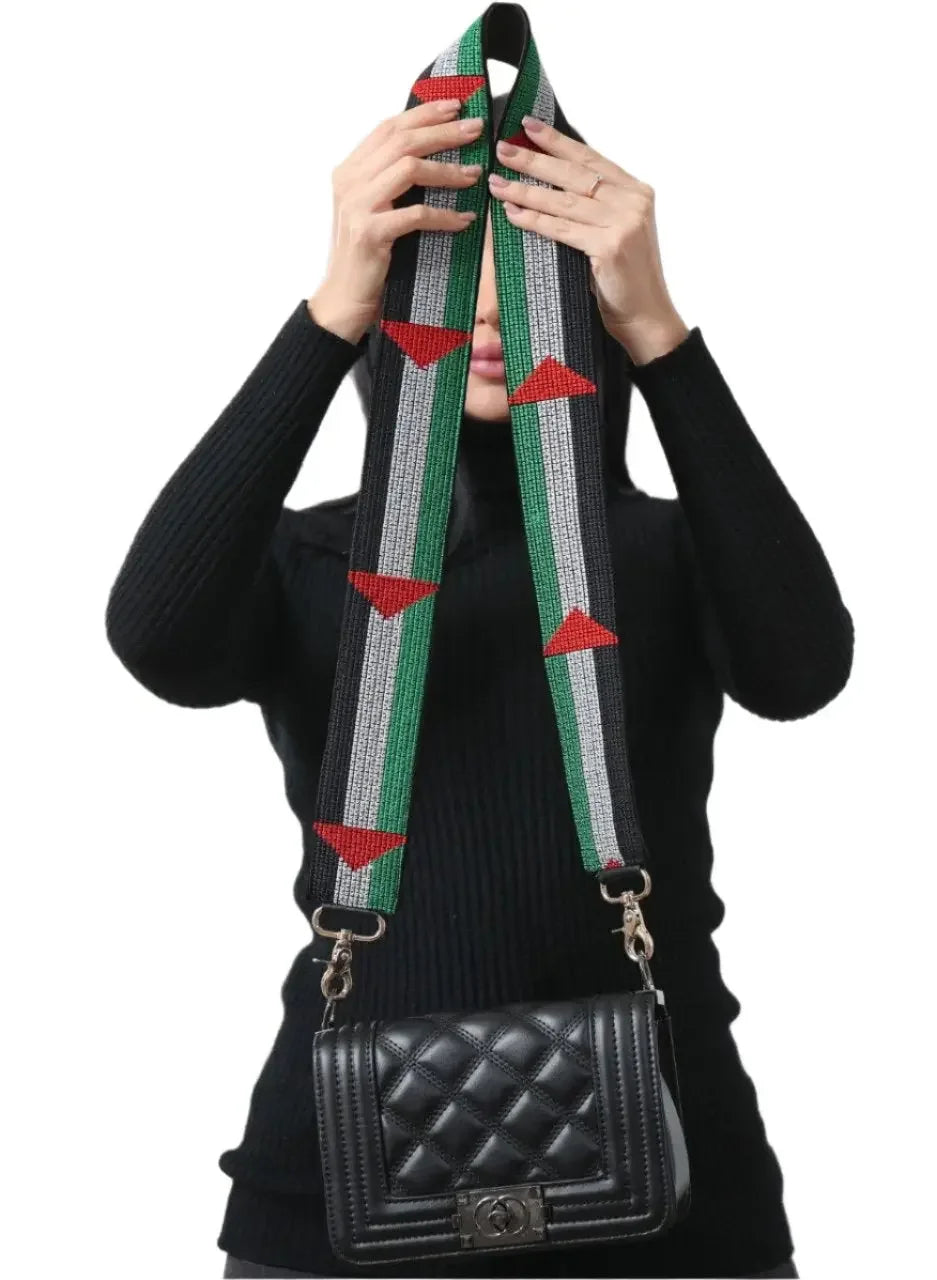 Palestinian embroidered purse strap with geometric patterns attached to a black quilted purse