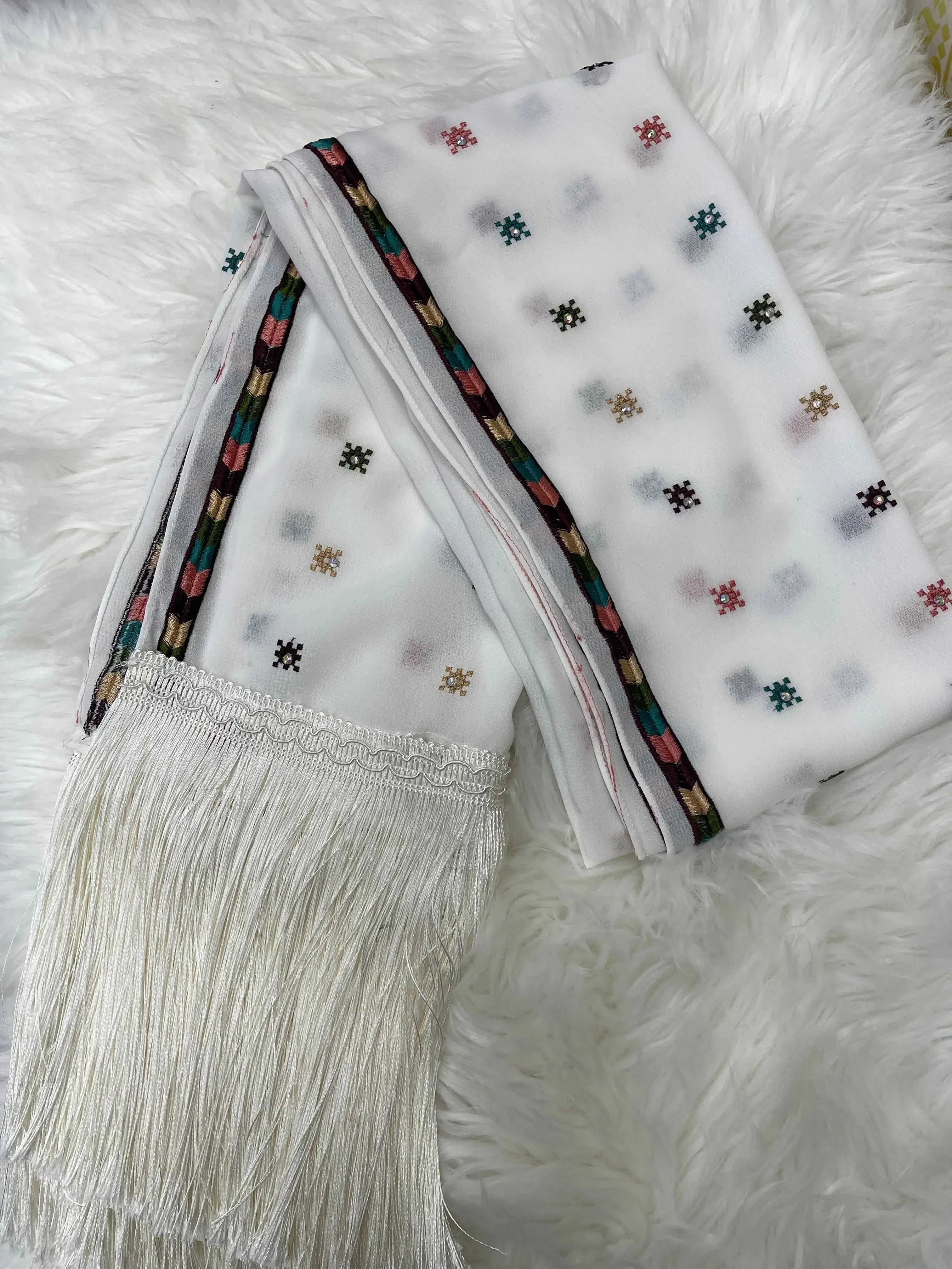 White Palestinian embroidered shawl with colorful floral motifs and fringe edges by Palestinian Elegance