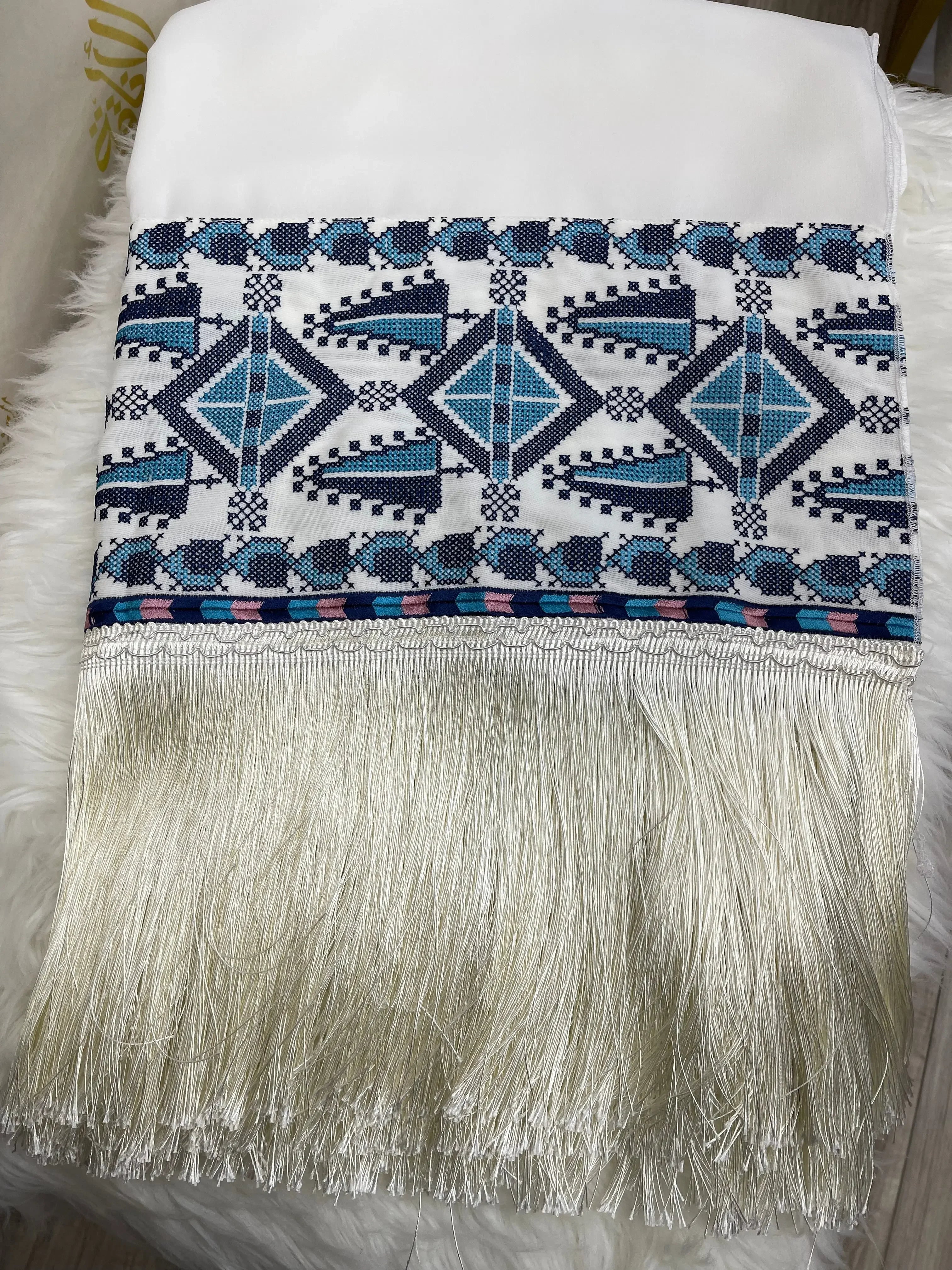 Palestinian embroidered shawl with intricate blue geometric patterns and white fringe detailing