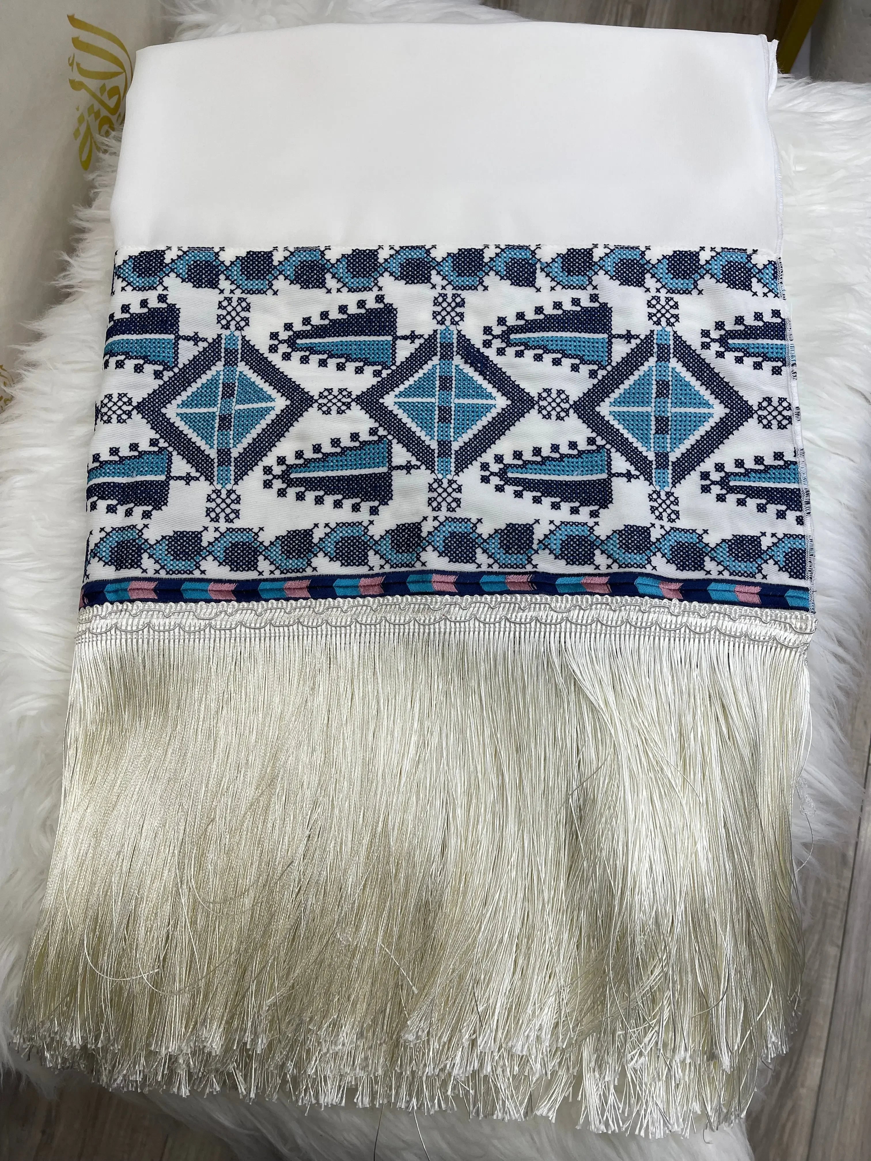 Palestinian embroidered shawl with intricate blue and black geometric designs and long white fringe