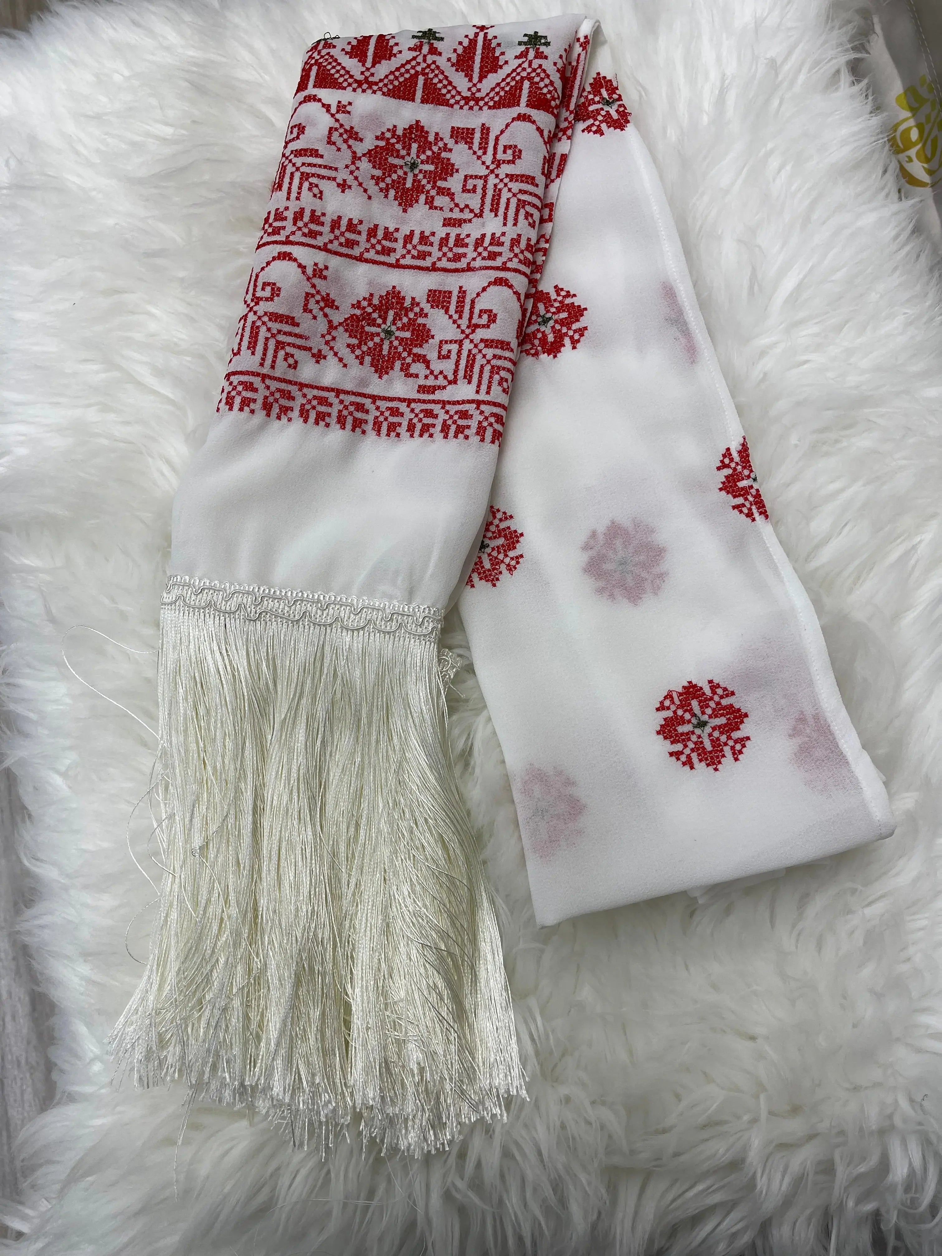 Palestinian embroidered shawl with intricate red geometric patterns and white fringe detailing