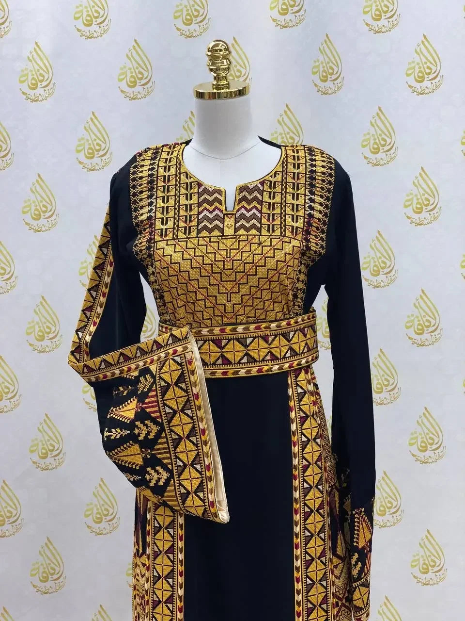 Palestinian embroidered thobe dress in black with intricate yellow and brown geometric embroidery by Palestinian Elegance
