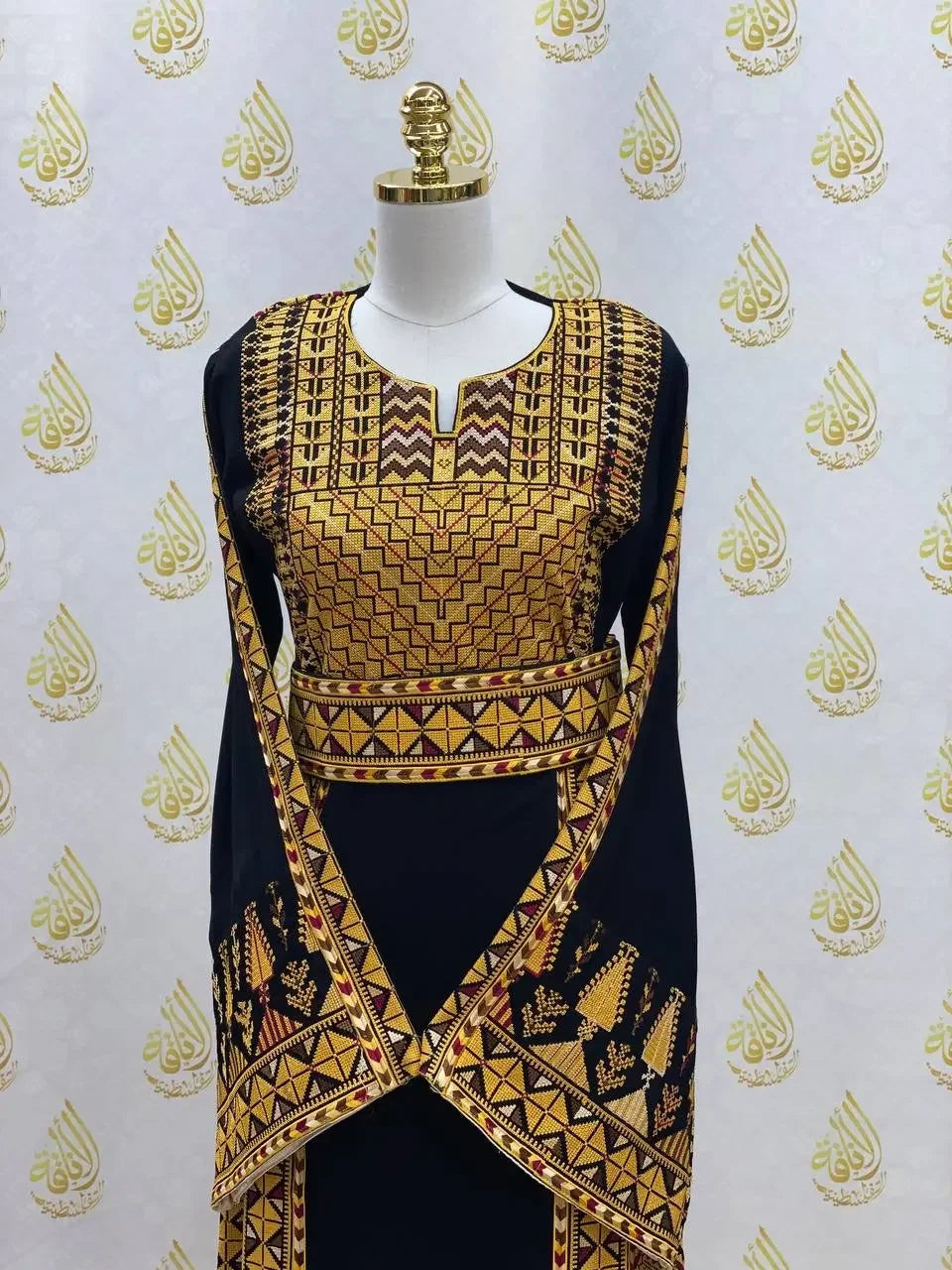 Palestinian embroidered thobe dress in black with intricate yellow geometric embroidery displayed on mannequin