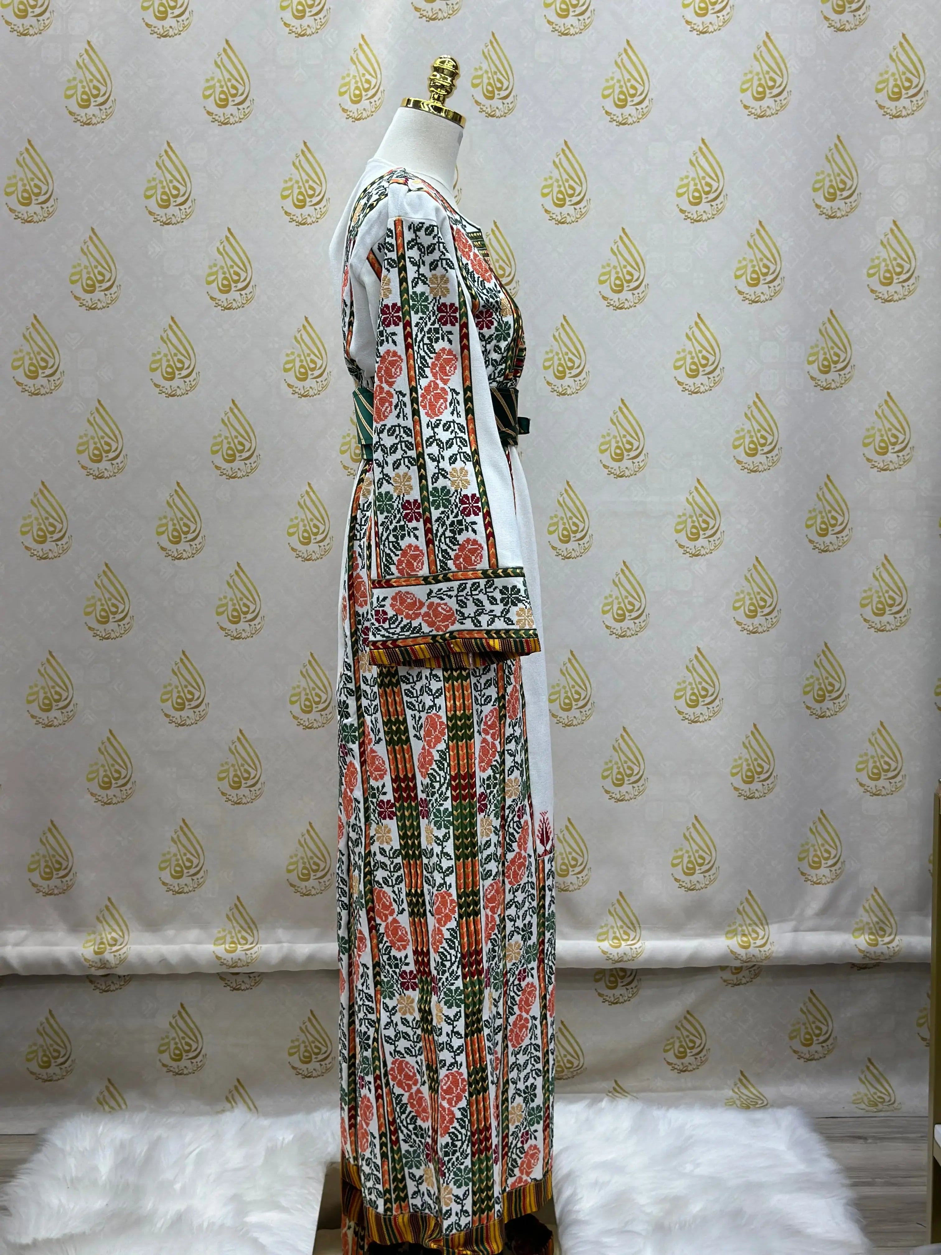 Palestinian embroidered thobe with colorful floral patterns displayed on a mannequin by Palestinian Elegance