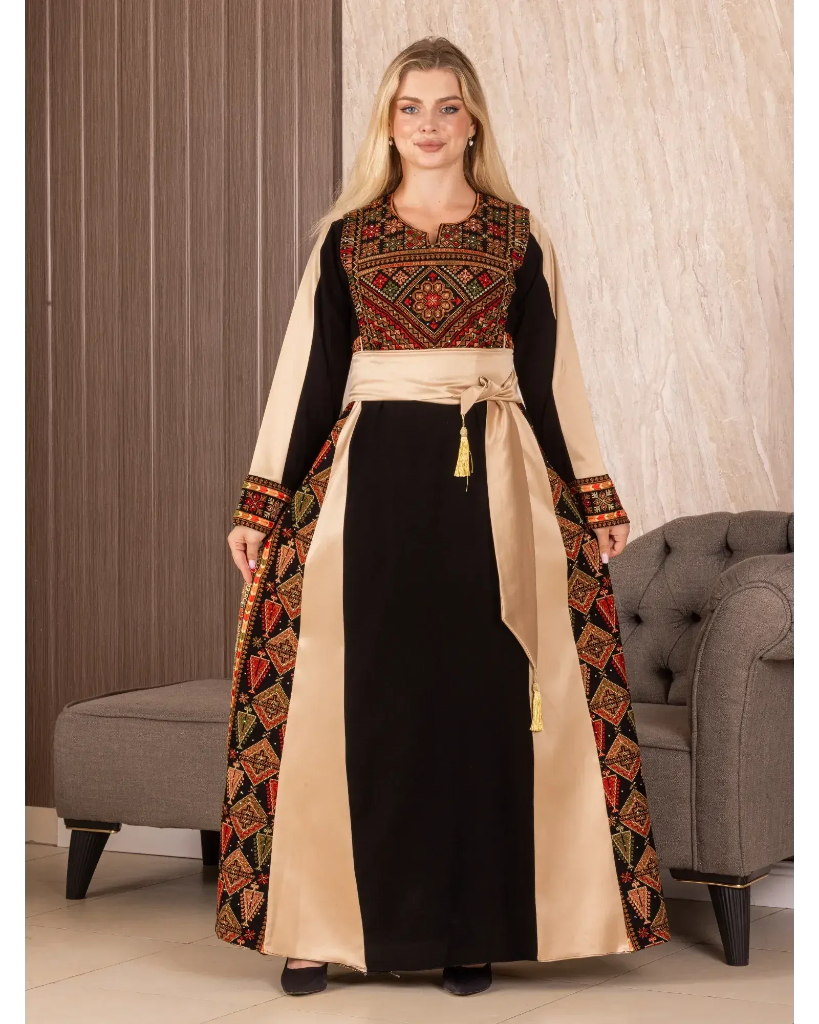 Woman wearing a Palestinian embroidered thoub with black and beige fabric and intricate red and gold embroidery