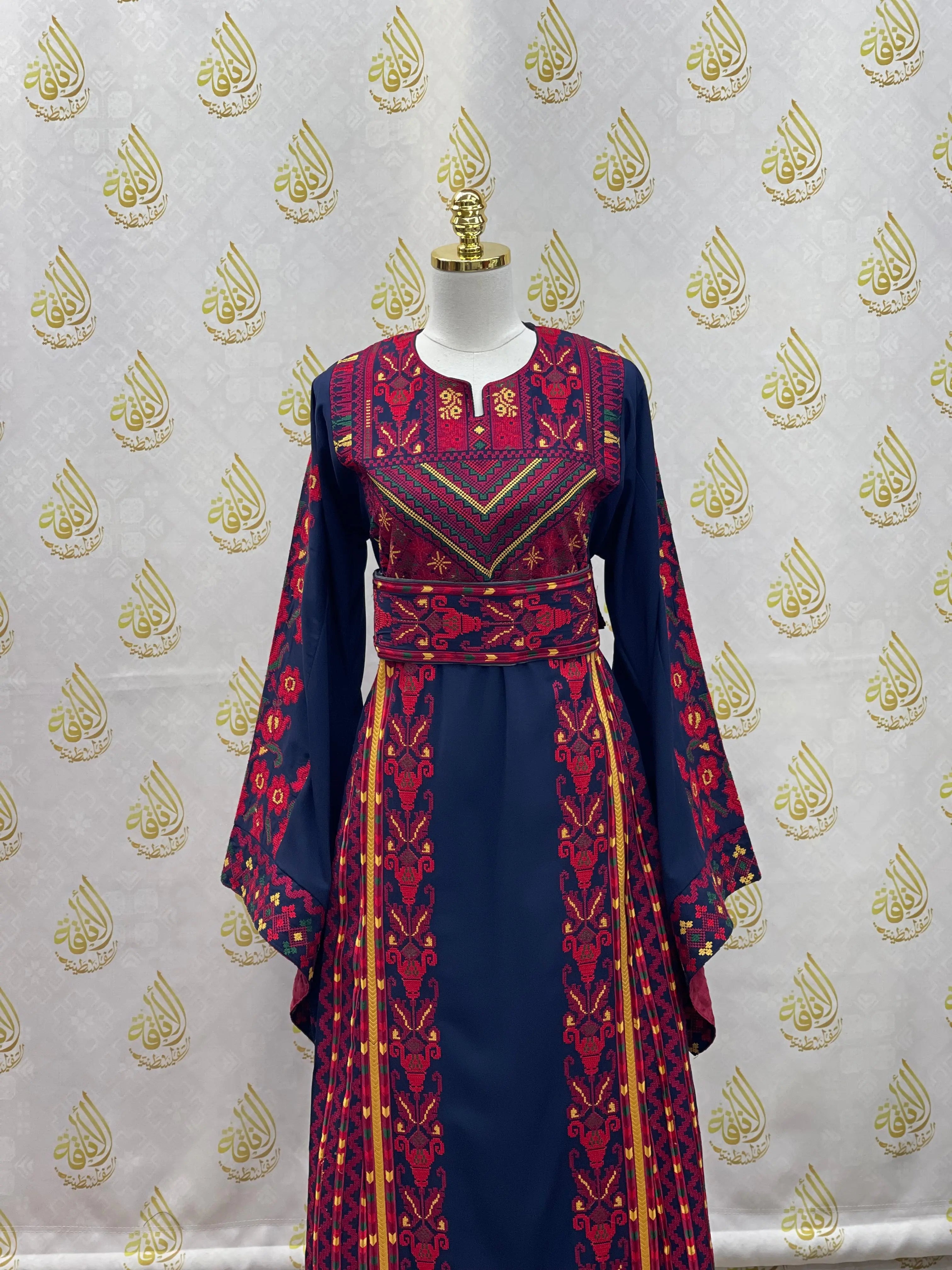 Palestinian embroidered thoub by Palestinian Elegance with intricate red and gold embroidery on navy fabric