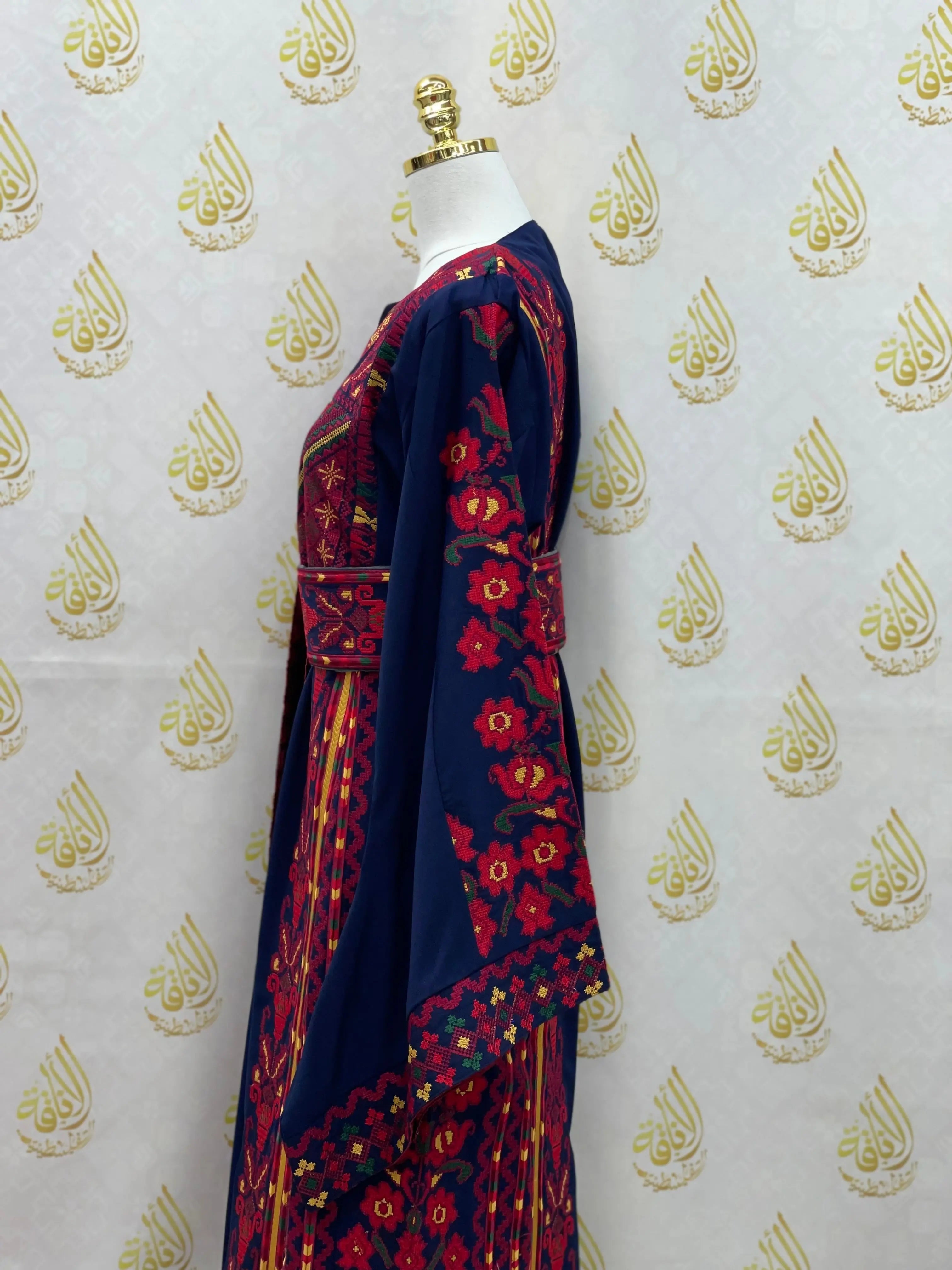 Palestinian embroidered thoub in navy blue with intricate red floral embroidery by Palestinian Elegance