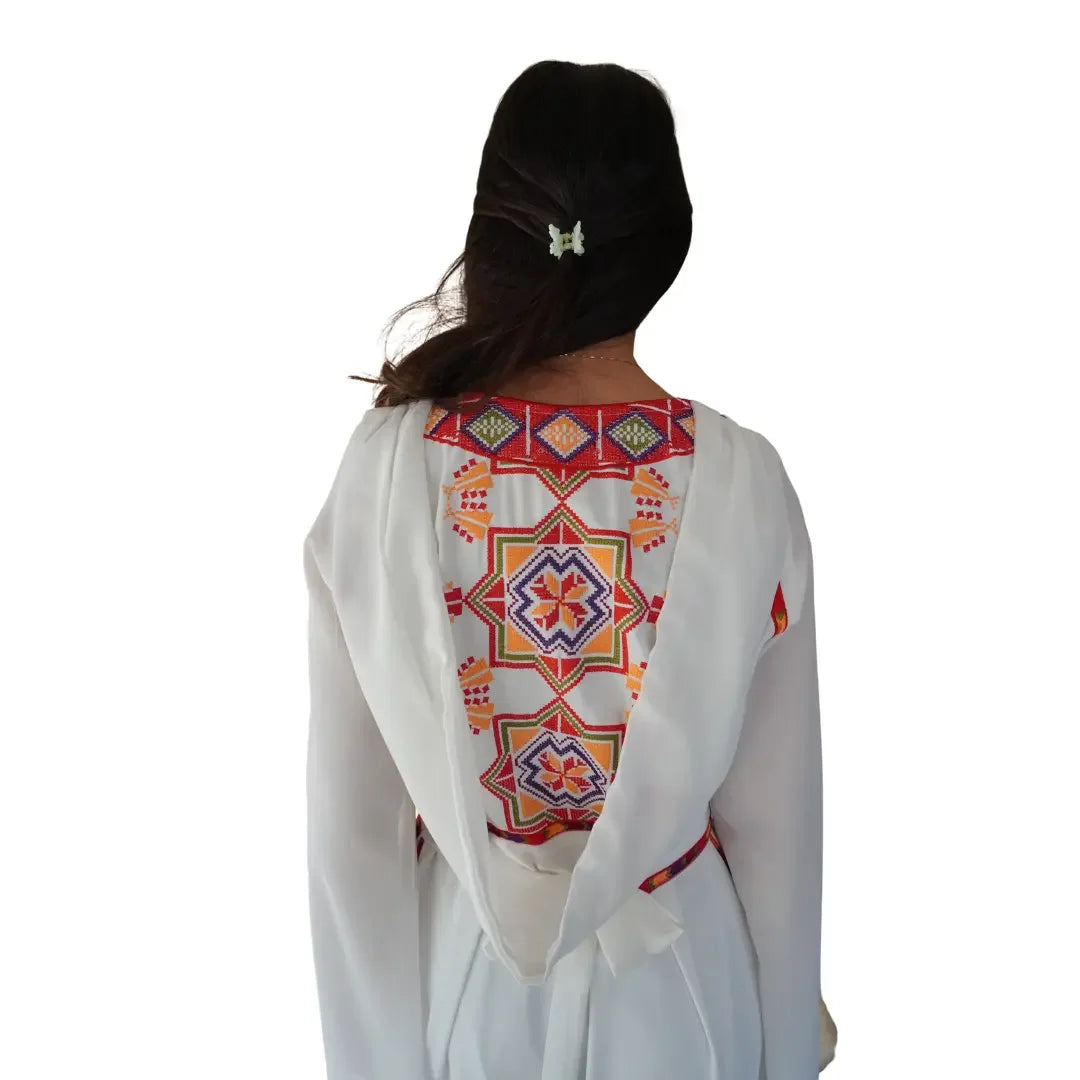 White Palestinian embroidery dress with colorful geometric patterns on back by Palestinian Elegance