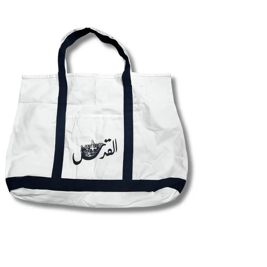 White Palestinian embroidery tote with black handles and embroidered Arabic design from Palestinian Elegance