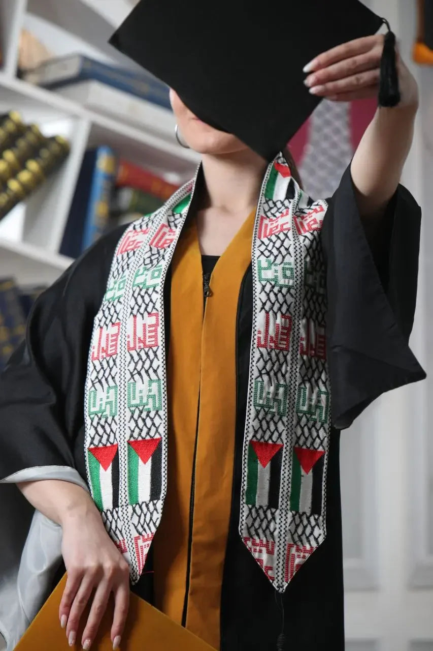 Palestinian graduation stole with traditional design worn by graduate in black robe holding cap