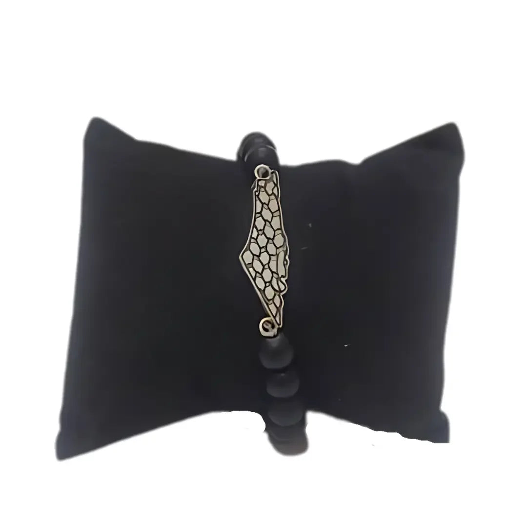 Palestinian kuffiyeh bracelet with black beads and silver map charm on black cushion