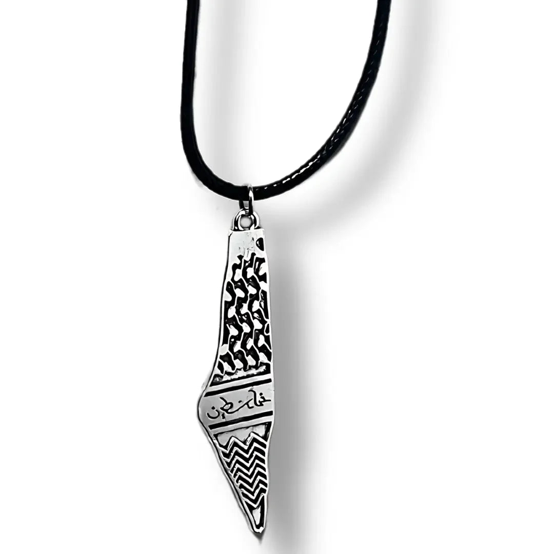 Palestinian kuffiyeh necklace with black and white patterned pendant on a black cord