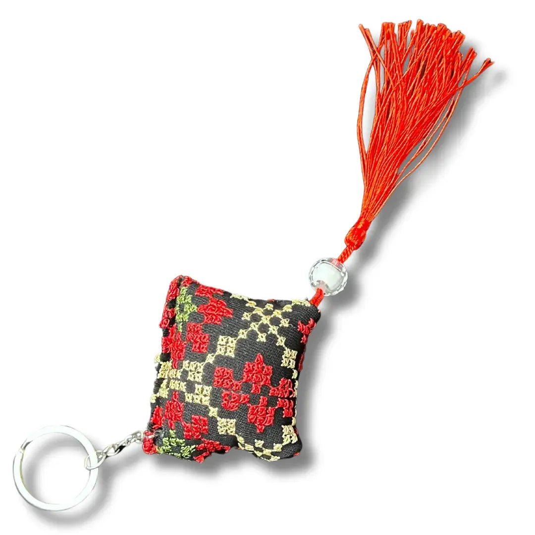 Palestinian tatreez keychains with traditional red and black embroidered patterns and red tassel