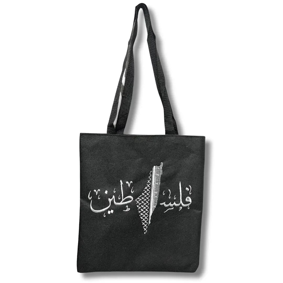 Black Palestinian tote bag with white Arabic calligraphy and traditional embroidery design