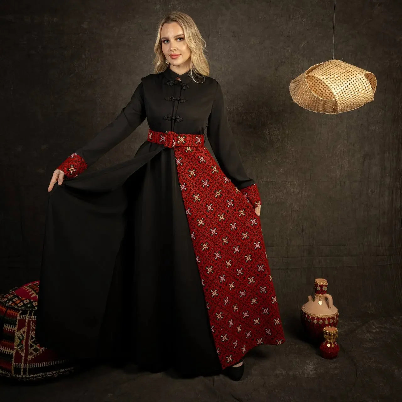 Woman wearing an embroidered Palestinian dress with black fabric and red patterned embroidery from Palestinian Elegance