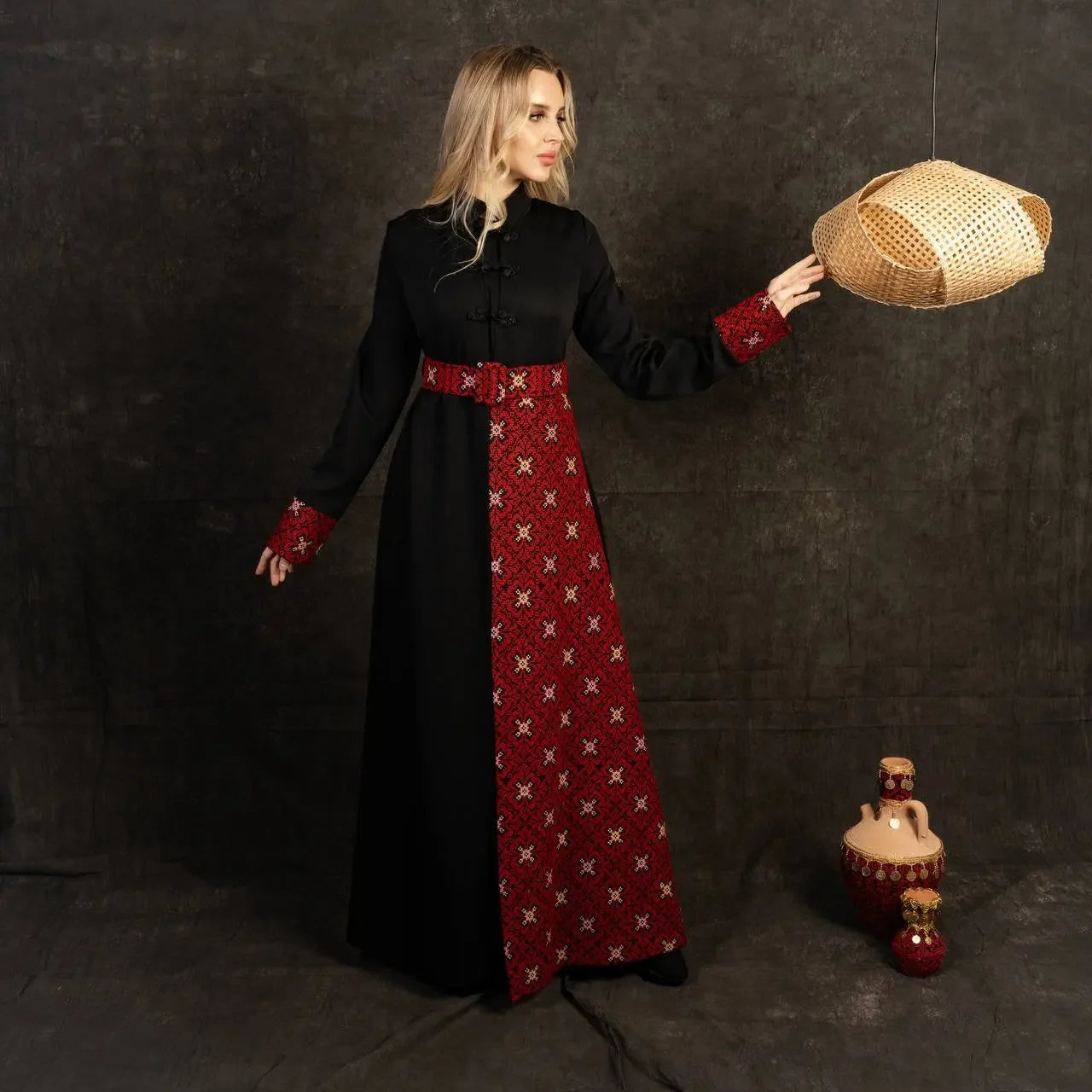 Woman wearing a black and red embroidered Palestinian dress with traditional pattern details