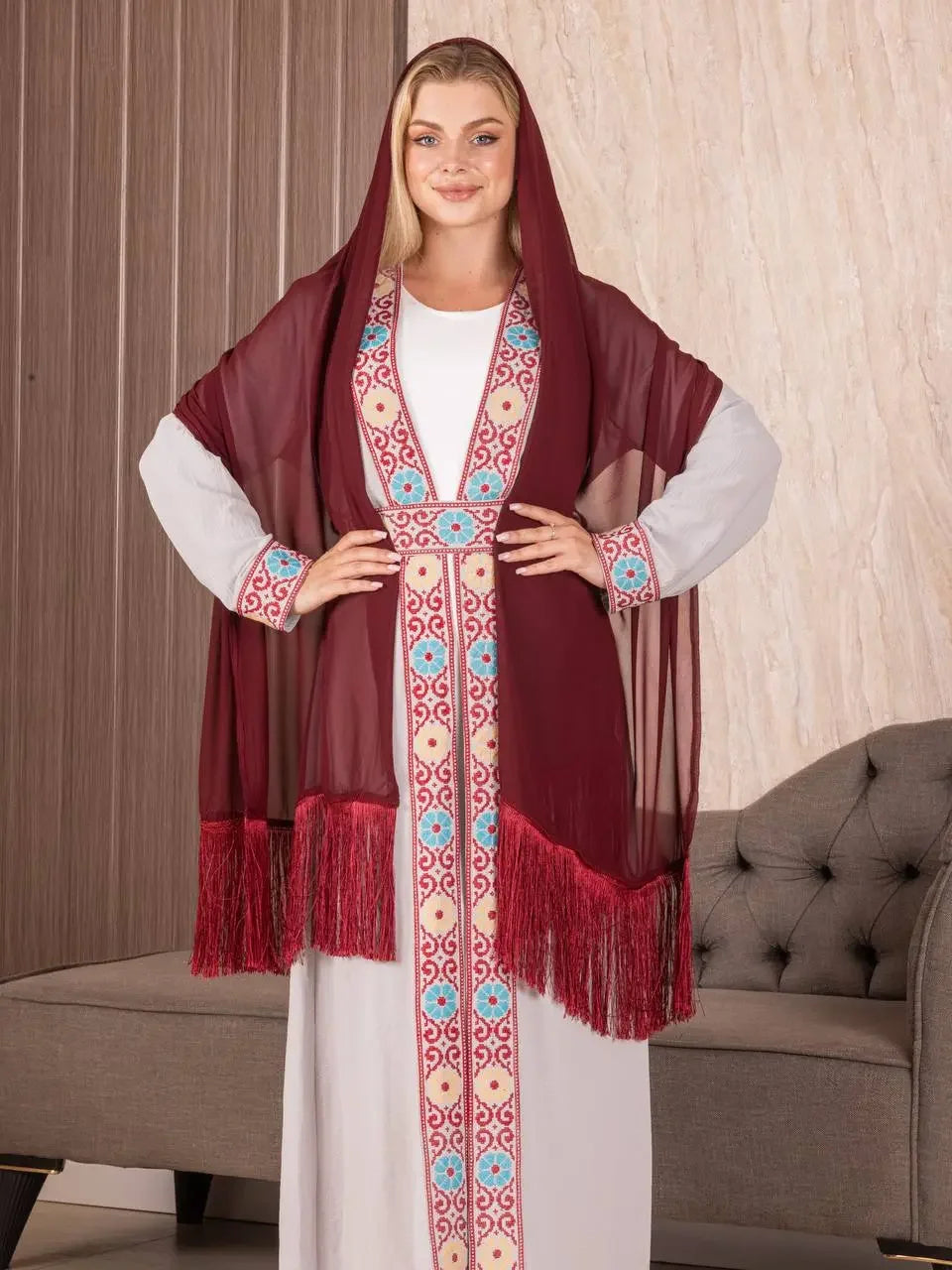 Traditional Palestinian khirka shawl in deep red with intricate embroidery worn over white dress