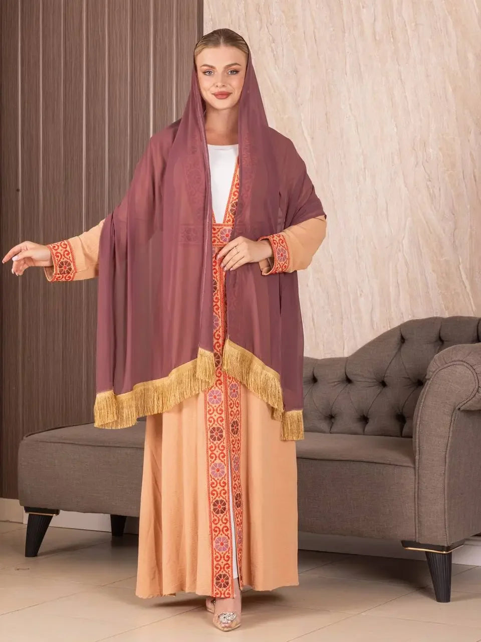 Traditional Palestinian khirka shawl with intricate embroidery and gold fringe worn by woman