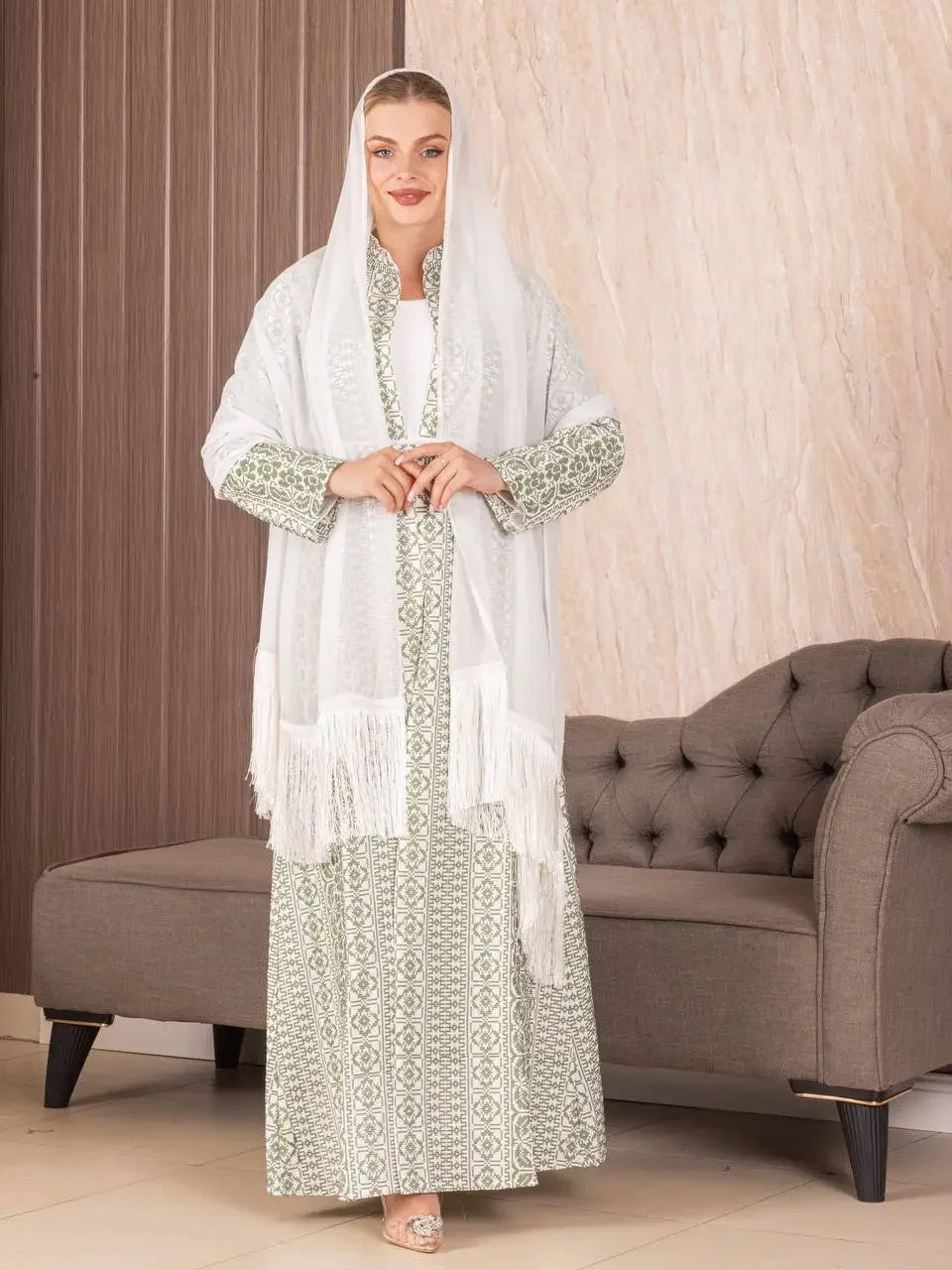 Woman wearing traditional Palestinian khirka shawl in white over green patterned dress by Palestinian Elegance