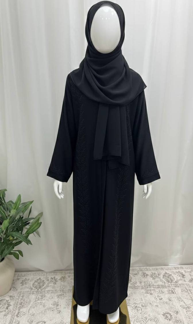 Mannequin wearing a black outfit with a hijab against a white curtain background