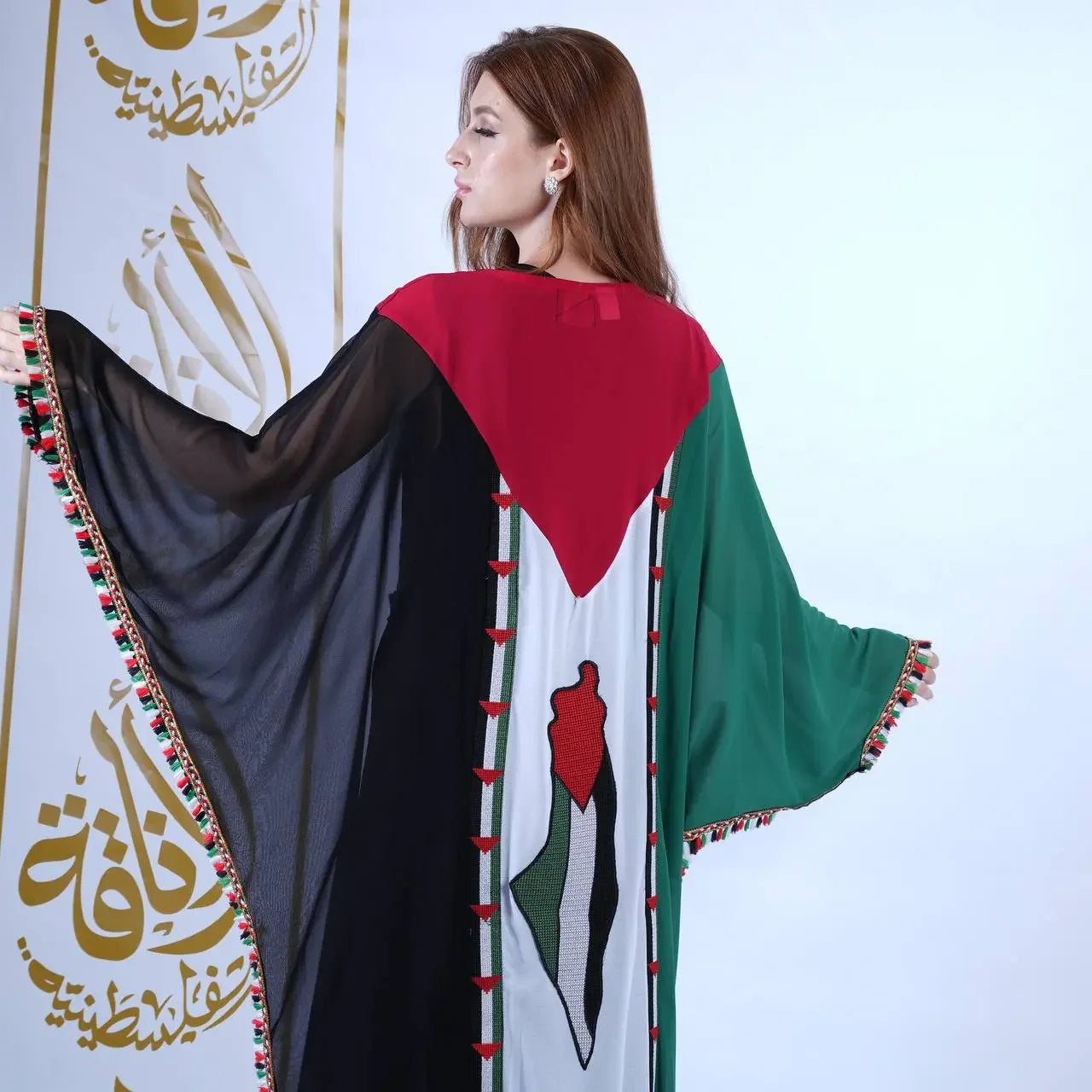 Woman wearing Palestinian flag dress casual style with green, red, black, and white colors and wide flowing sleeves