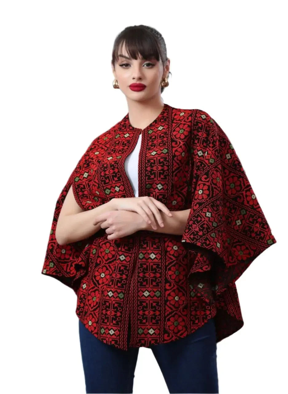 Woman wearing a Palestinian embroidered cape in red with traditional intricate patterns by Palestinian Elegance