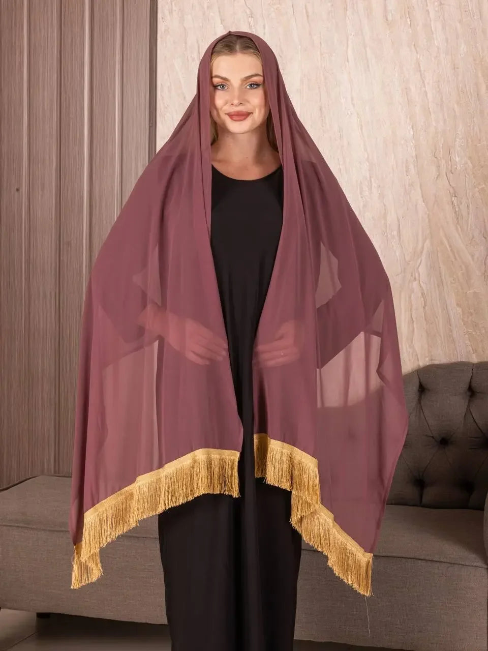 Traditional Palestinian khirka shawl in deep maroon with gold fringe worn by woman over black dress