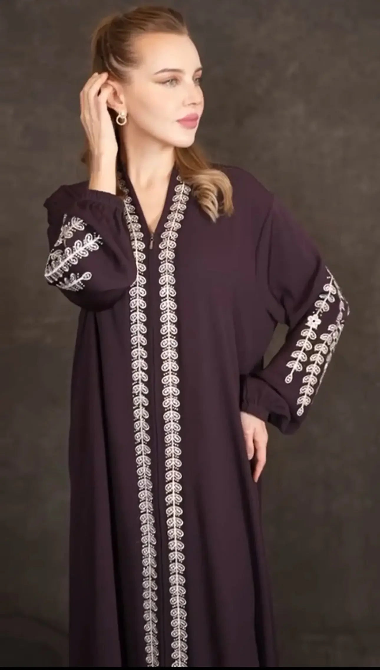 Plus size embroidered abaya by Palestinian Elegance in dark fabric with intricate white embroidery on sleeves and front