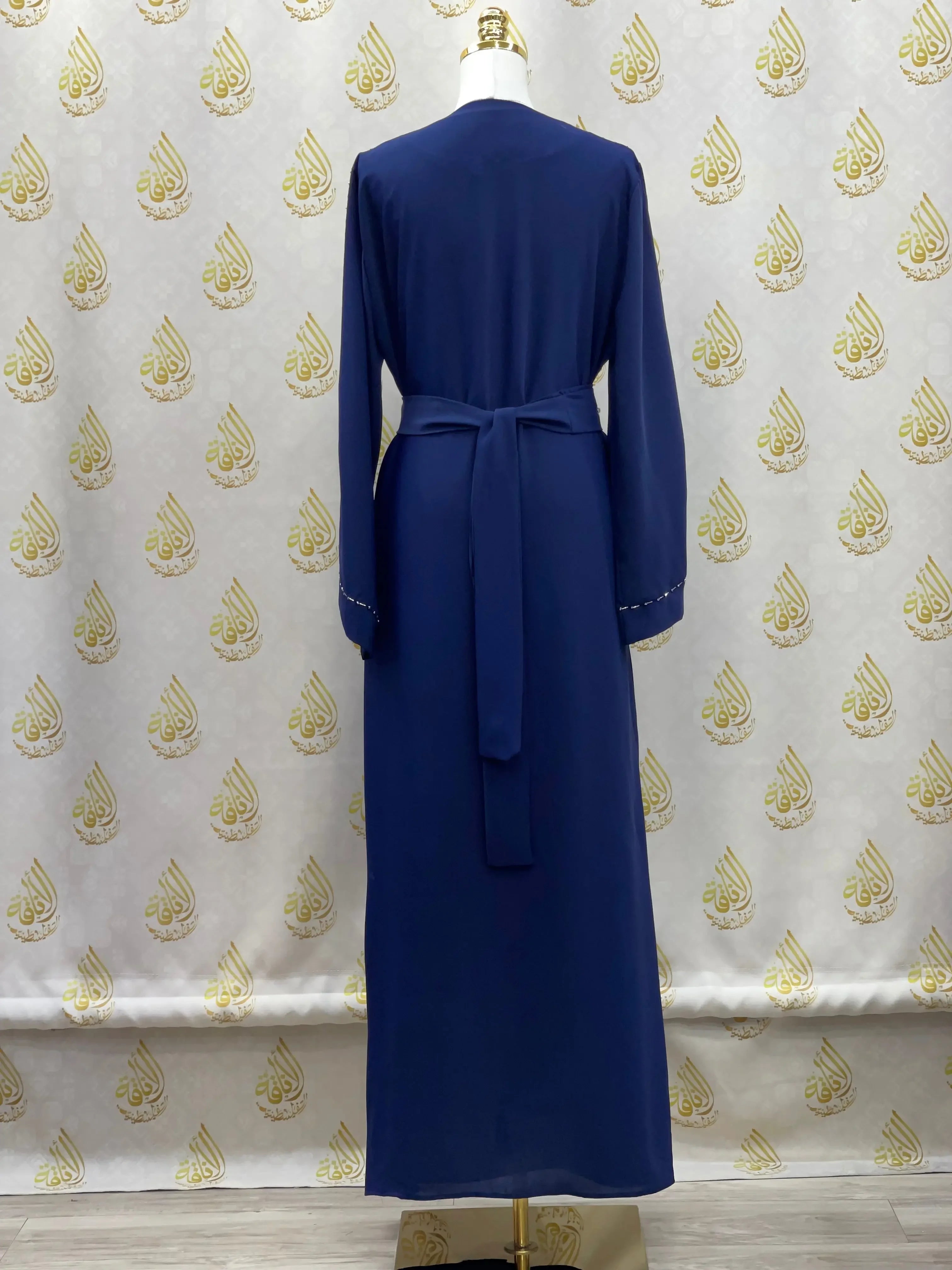 Back view of a navy blue rhinestone moroccan abaya by Palestinian Elegance with long sleeves and waist tie