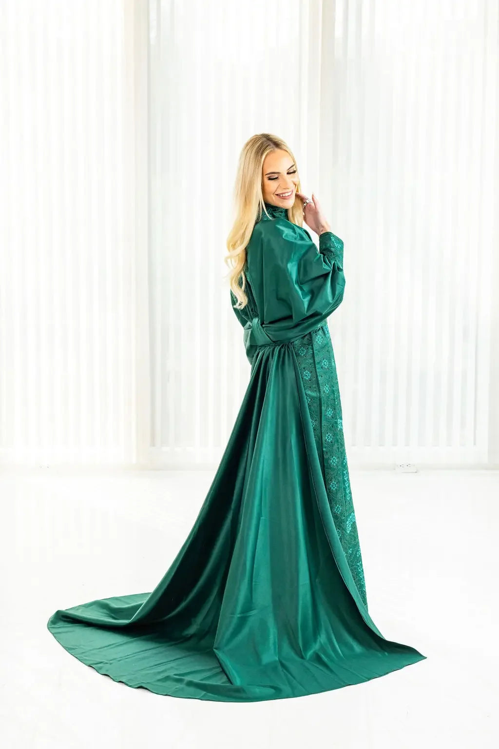 Green satin bridal dress with cape featuring intricate Palestinian Elegance embroidery details