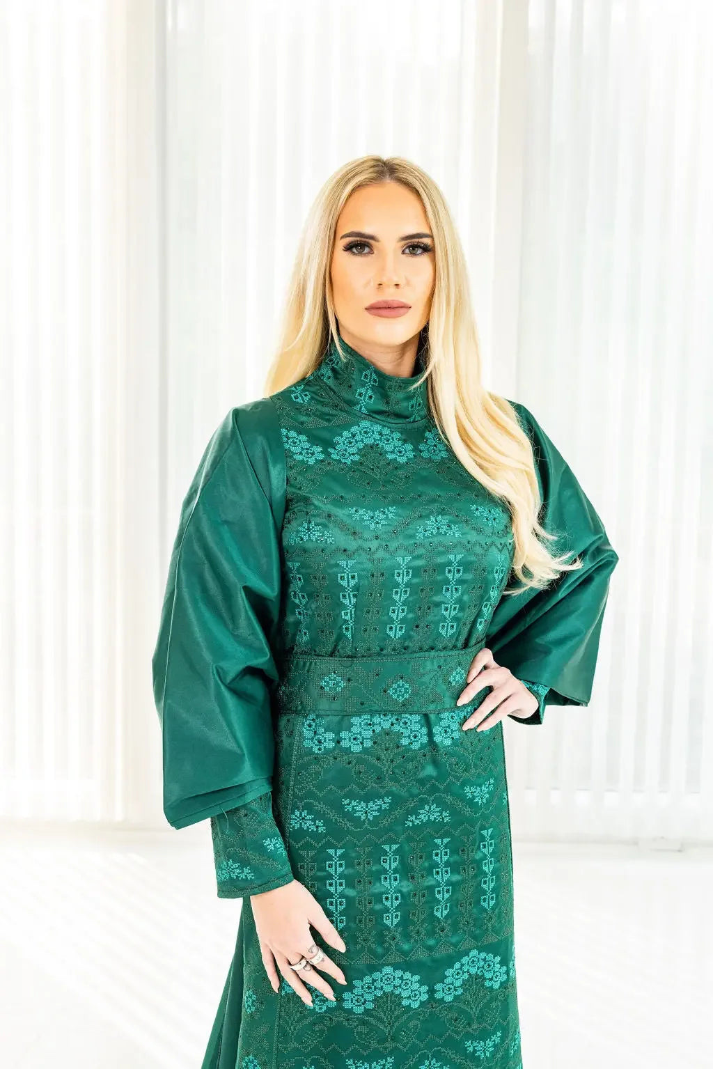 Green embroidered satin bridal dress with cape featuring intricate floral designs from Palestinian Elegance