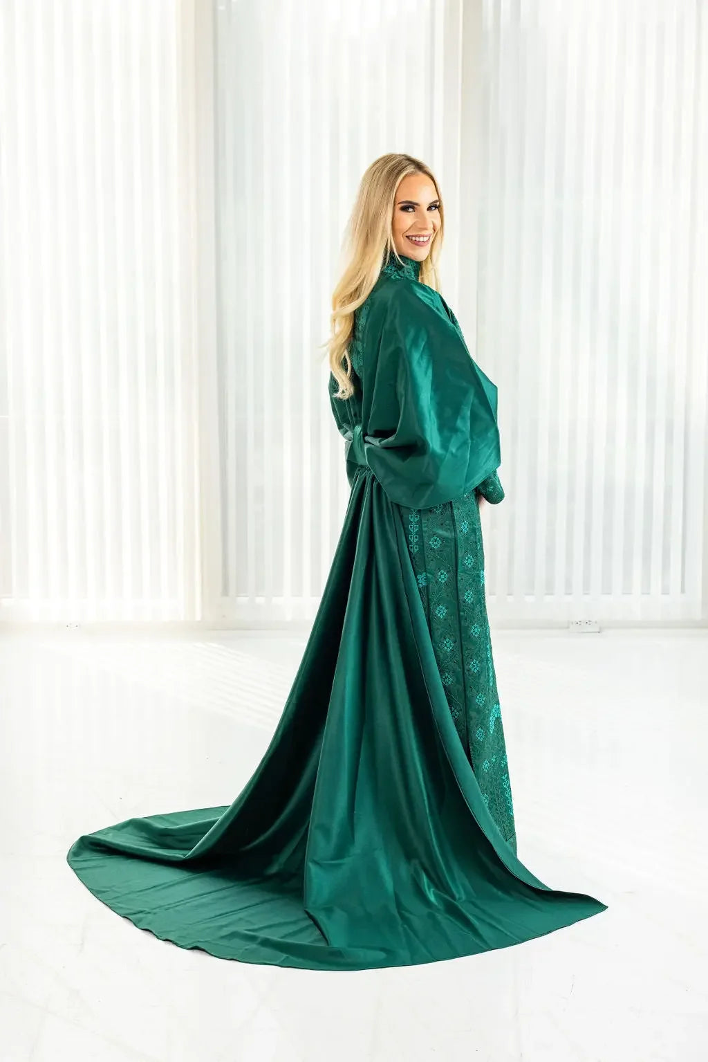 Green satin bridal dress with cape featuring intricate Palestinian Elegance embroidery