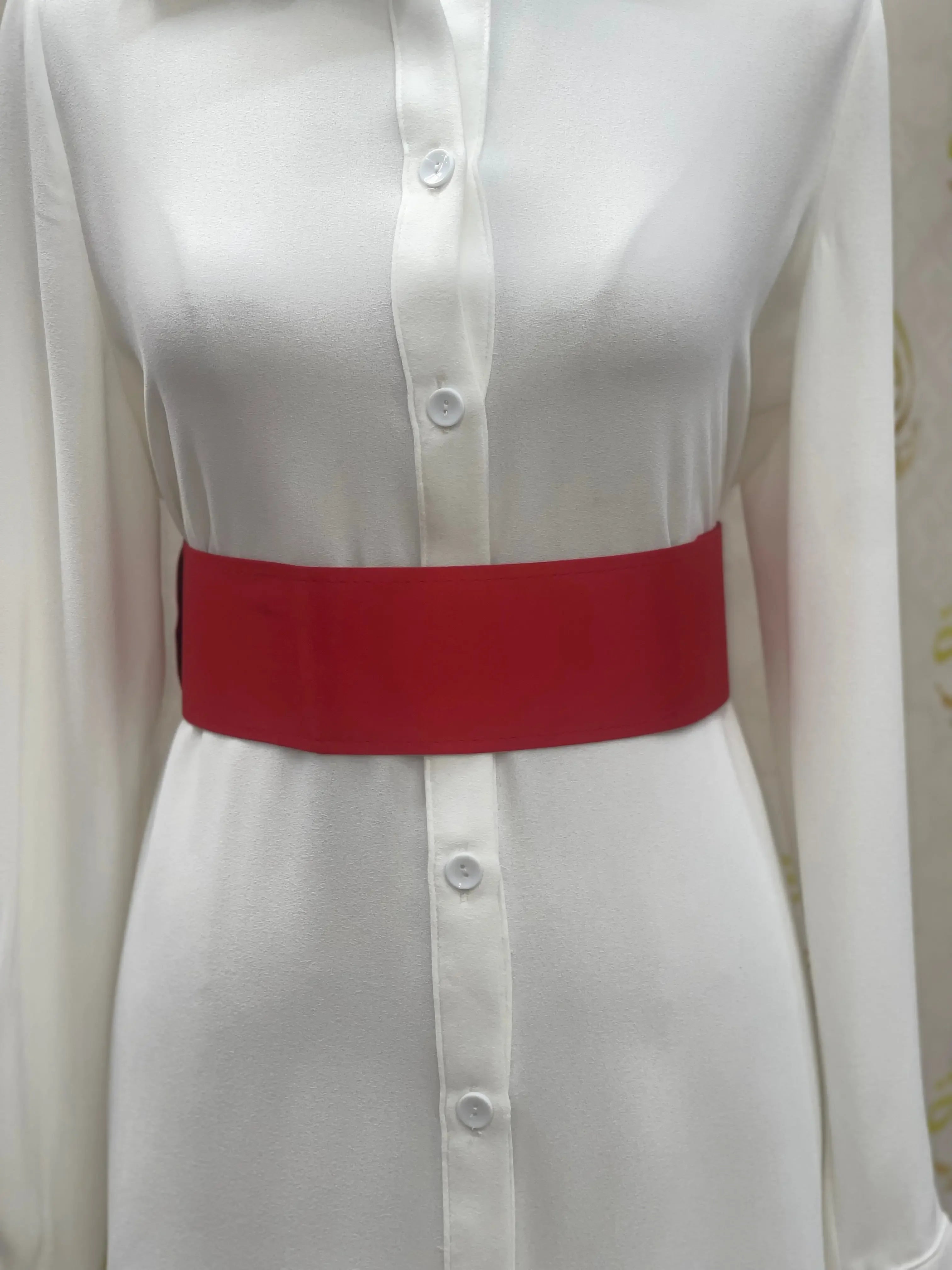 Red satin waist belt by Palestinian Elegance worn over white button-down dress
