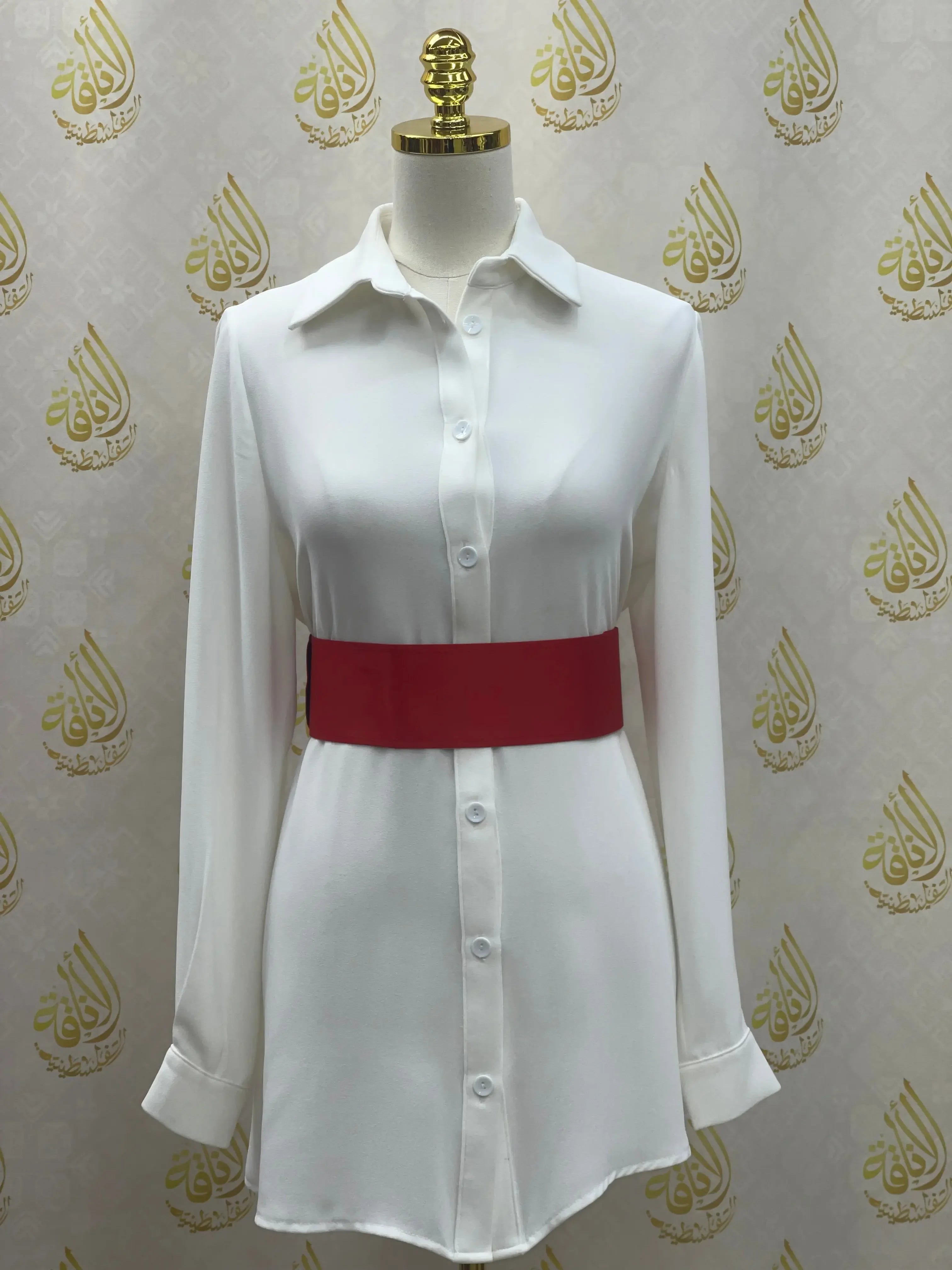 White button-down dress paired with a red satin waist belt by Palestinian Elegance accessories