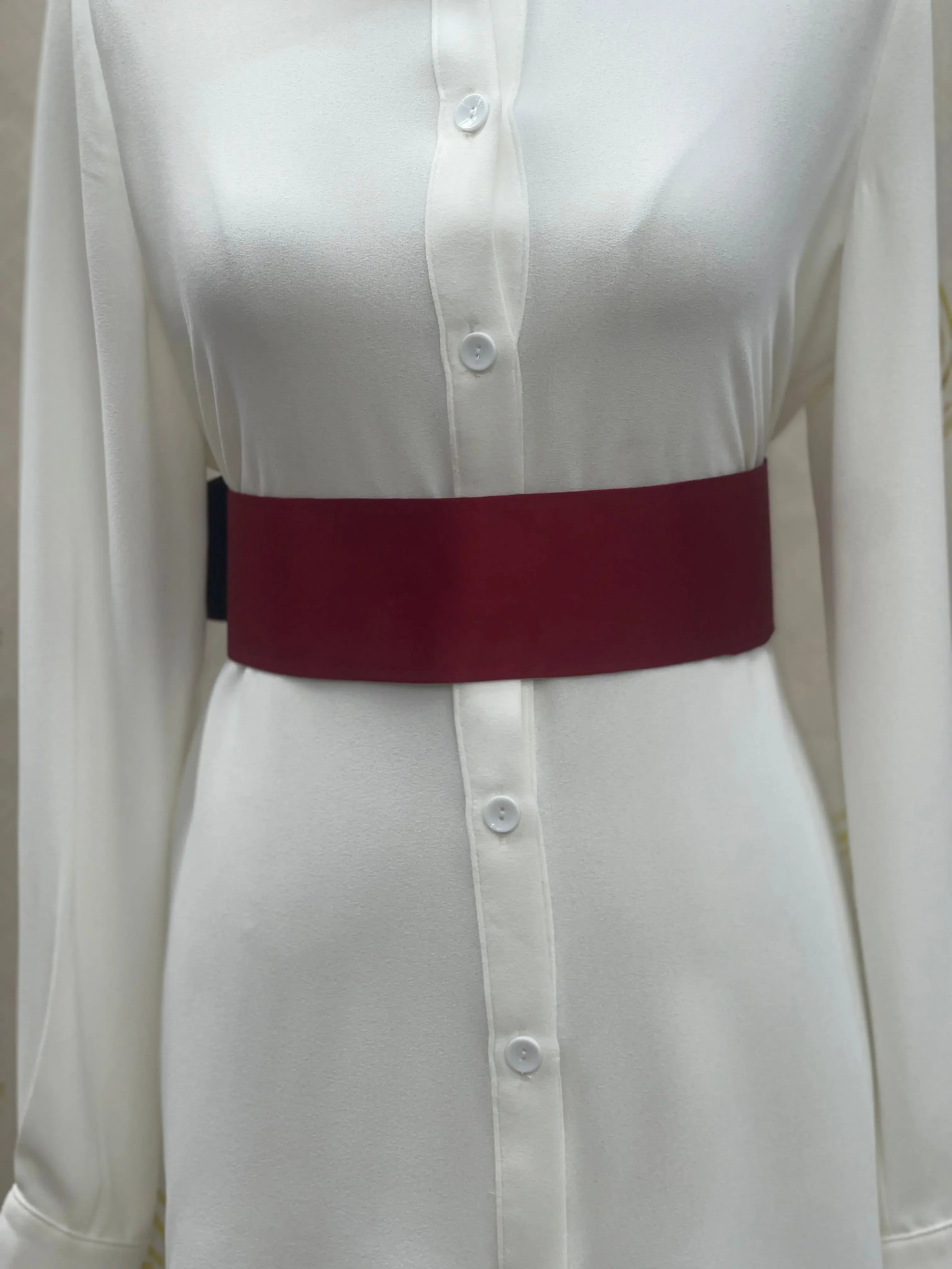 Palestinian Elegance satin waist belt in deep red worn over a white button-up dress