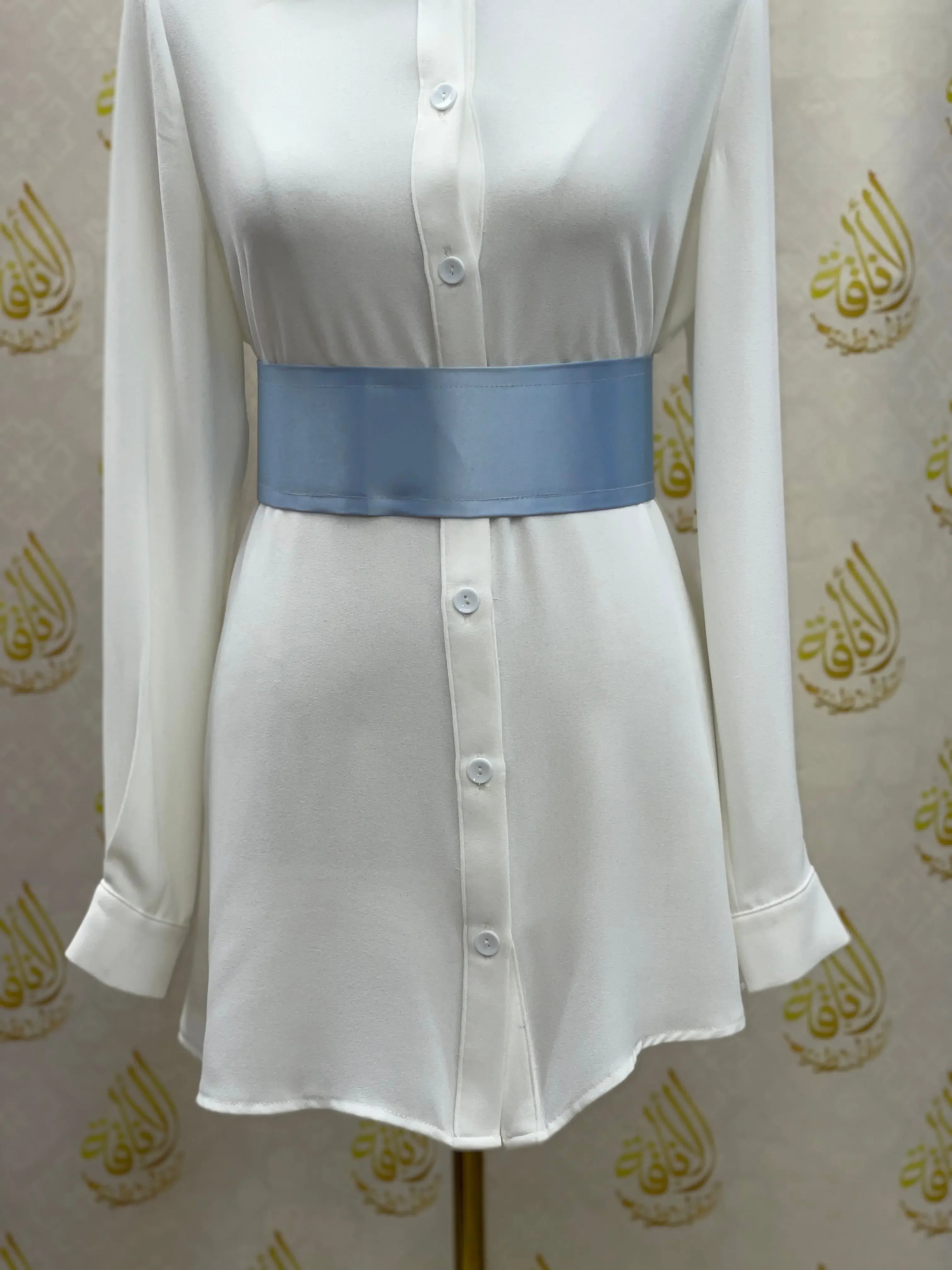 Palestinian Elegance blue satin waist belt styled over white button-down dress shirt
