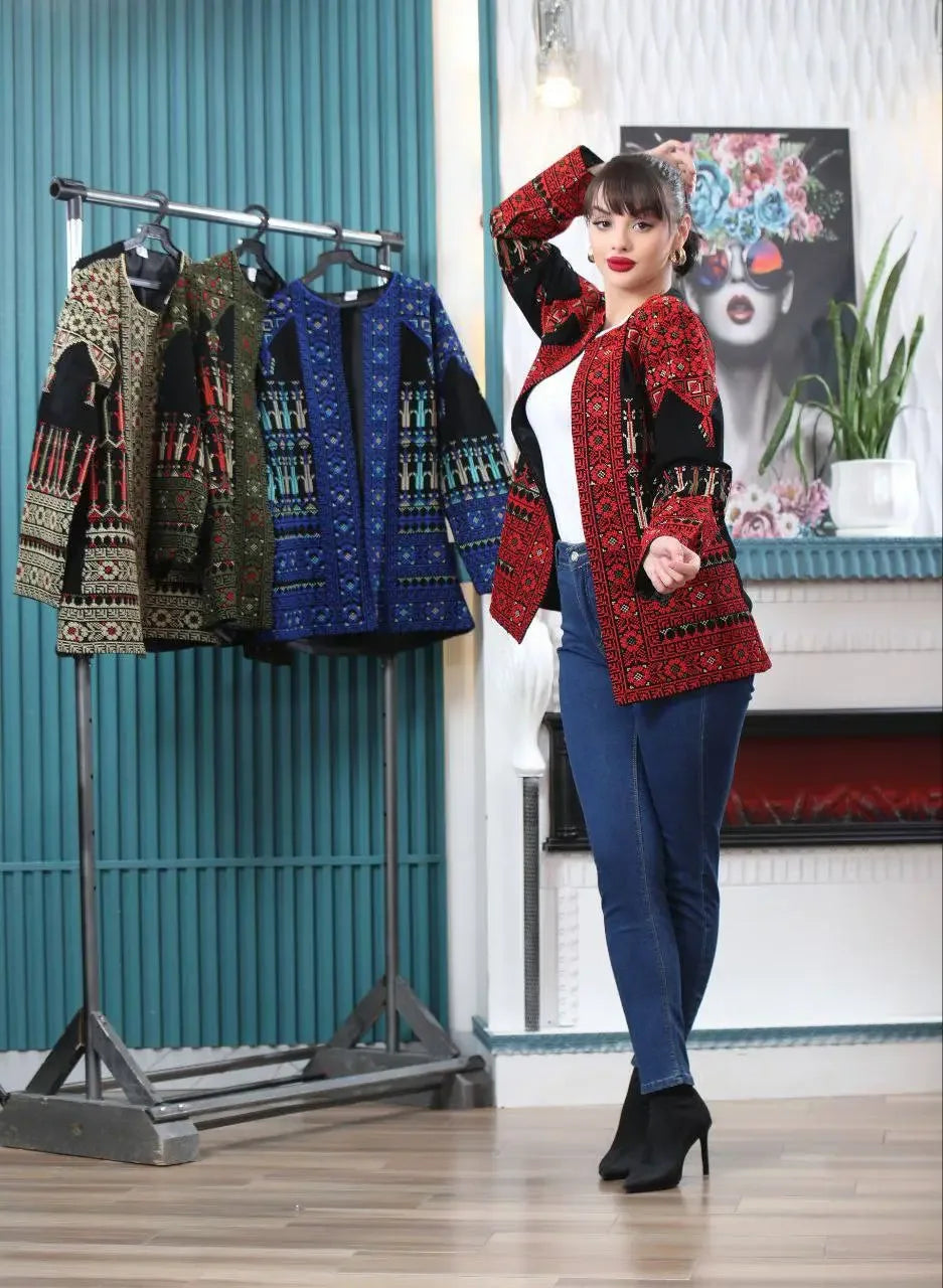 Woman wearing a red tatreez embroidered jacket from Palestinian Elegance styled with casual jeans and black boots