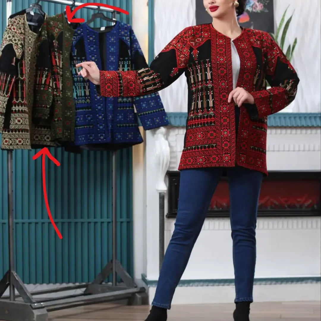 Palestinian Elegance tatreez embroidered jacket in red worn by a woman with additional jackets hanging on a rack