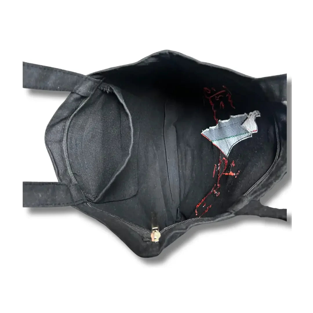 Inside view of Palestinian Elegance black tatreez tote bag showing embroidered interior pocket