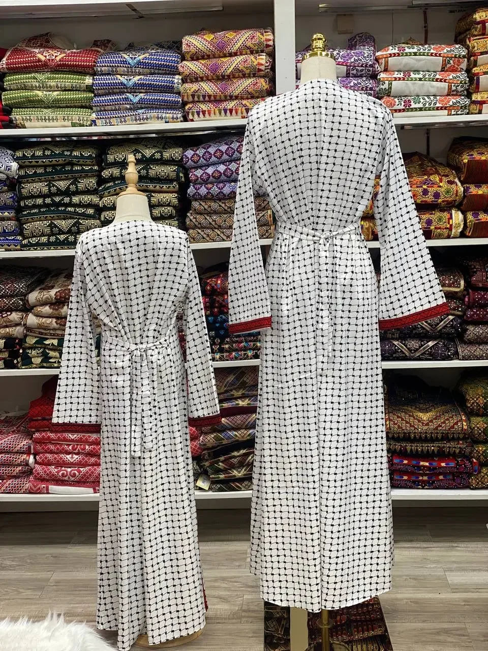 Palestinian Elegance teen girl abaya dress embroidery in white with black detailed patterns on mannequins