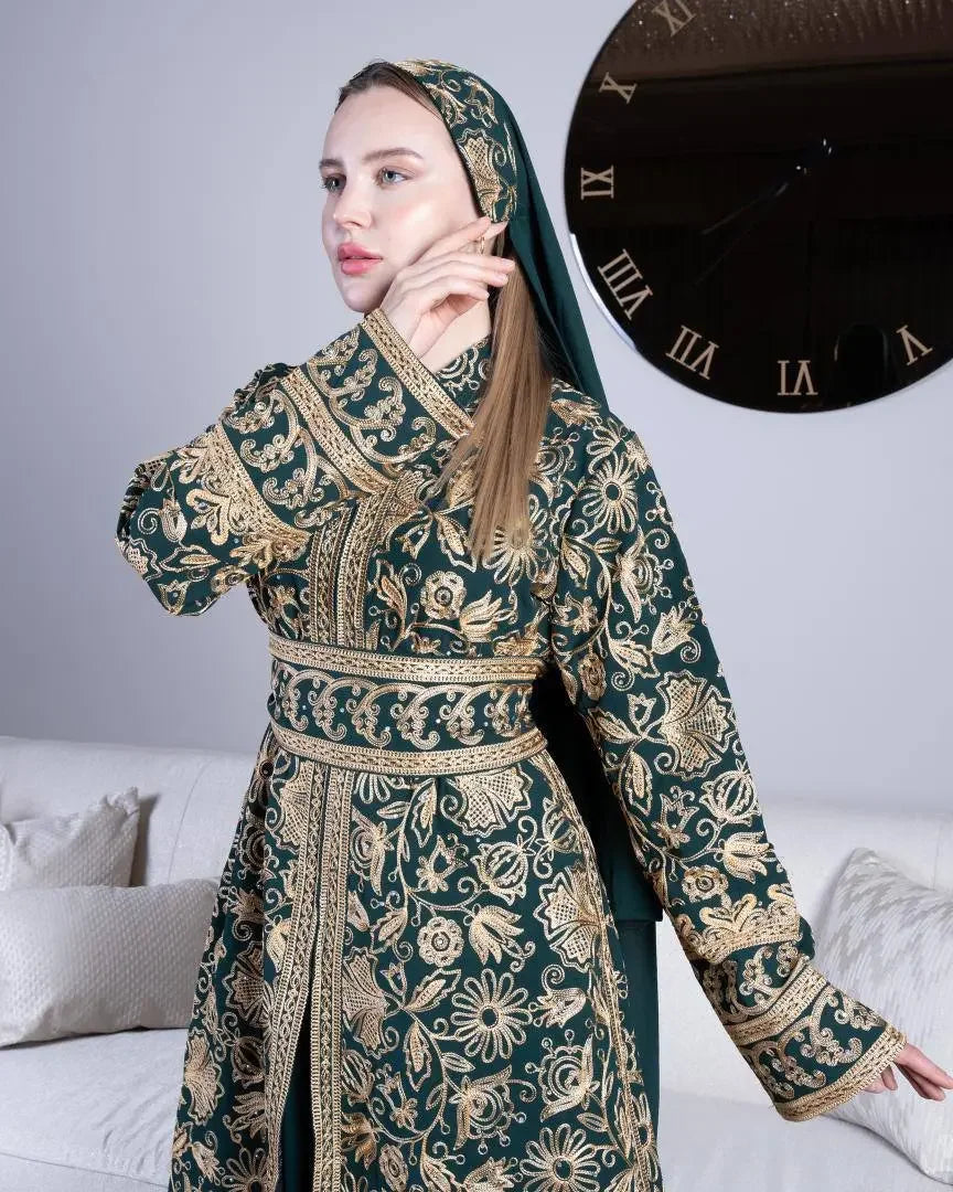 Woman wearing green traditional embroidered kaftan with intricate gold floral patterns and matching headscarf