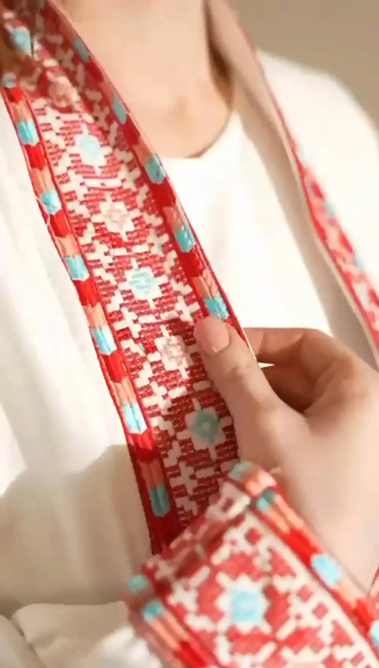Close-up of Palestinian Elegance traditional embroidery suit featuring detailed red and blue stitch patterns