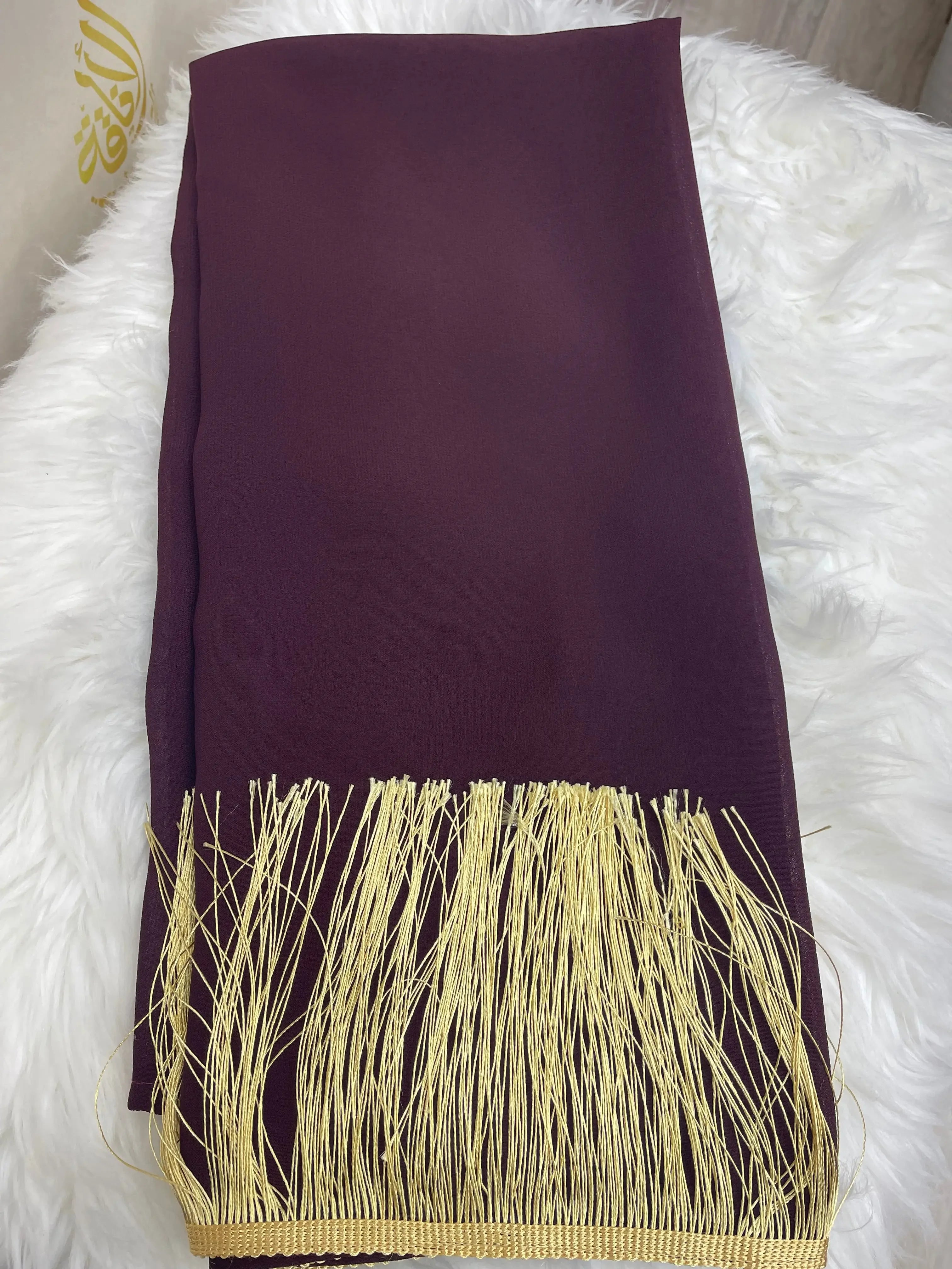 Palestinian Elegance traditional khirka shal in deep purple with golden fringe detailing on white fur background