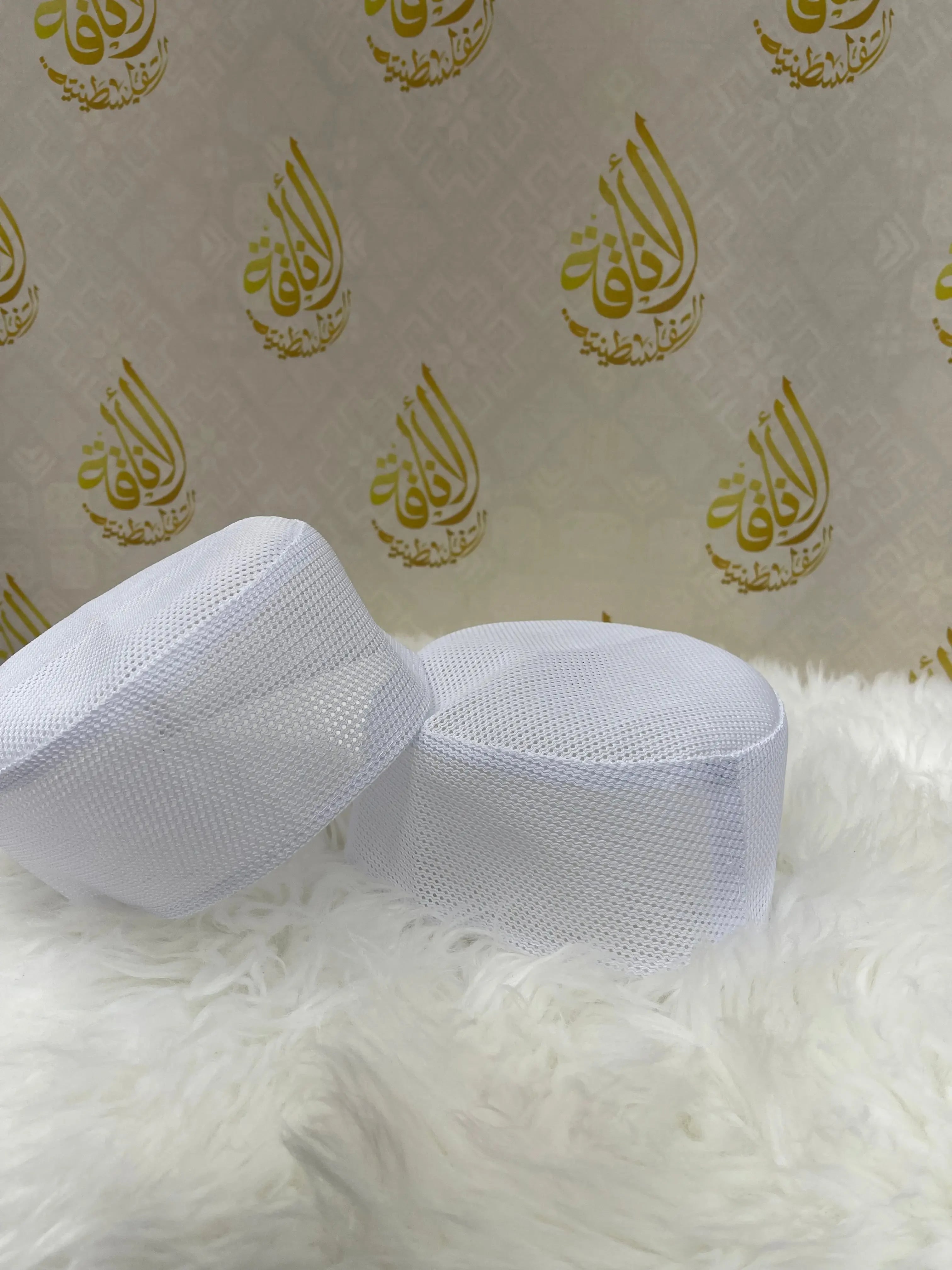 Traditional Palestinian hat for men in white mesh fabric placed on a soft white surface