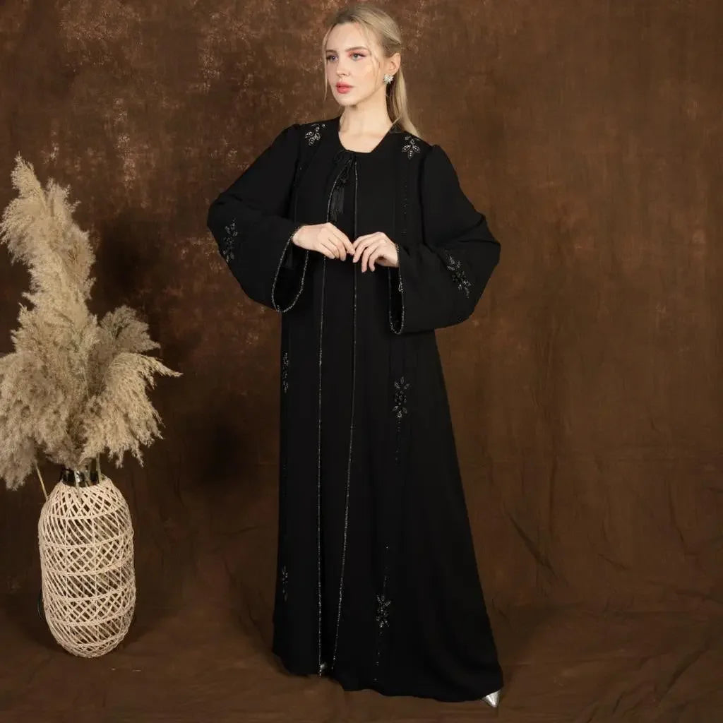 Palestinian Elegance black abaya with subtle floral embroidery and loose sleeves on model